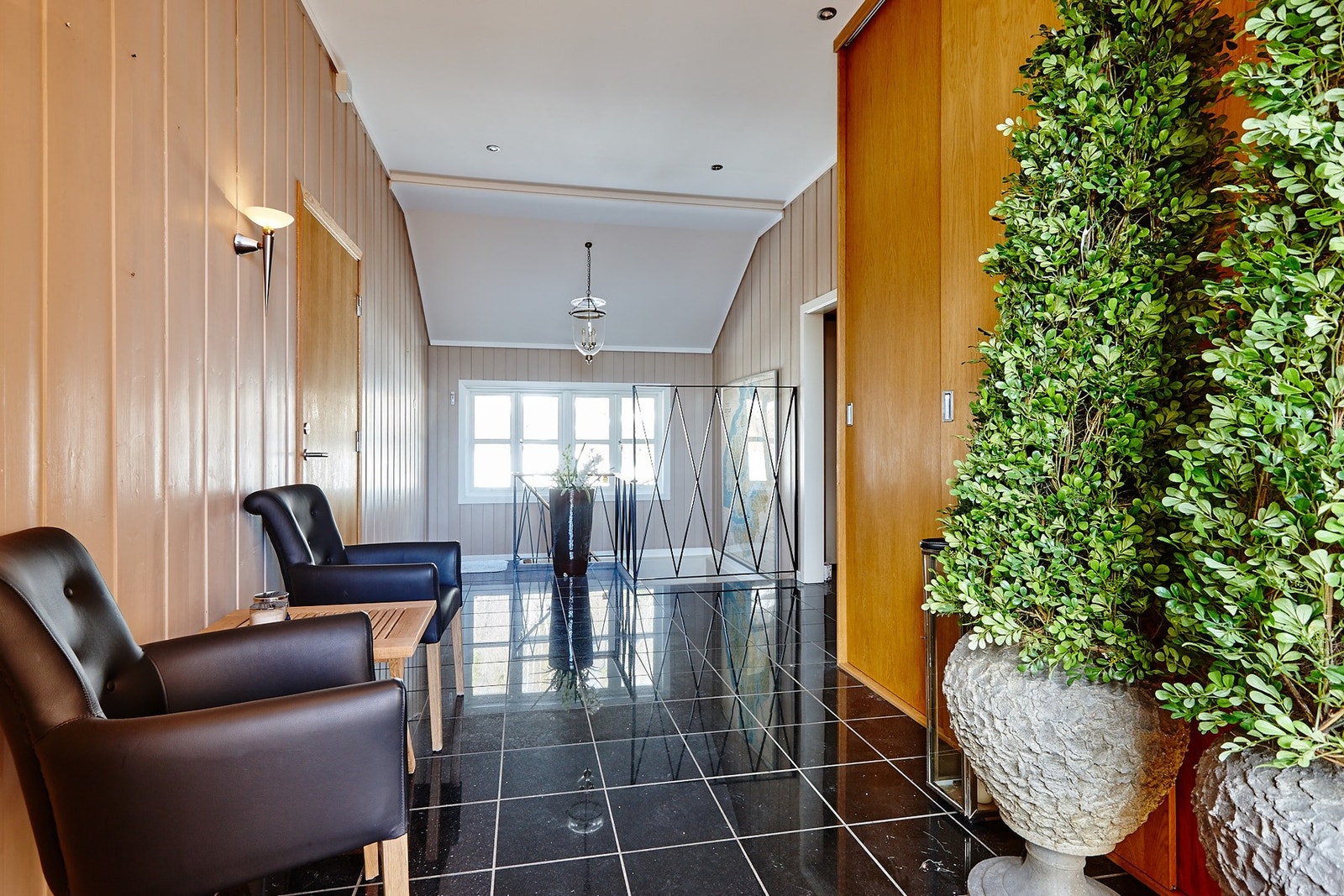 Innbydende entrè med flislagt gulv og plass oppbevaring i garderobeskap. Galleribilde