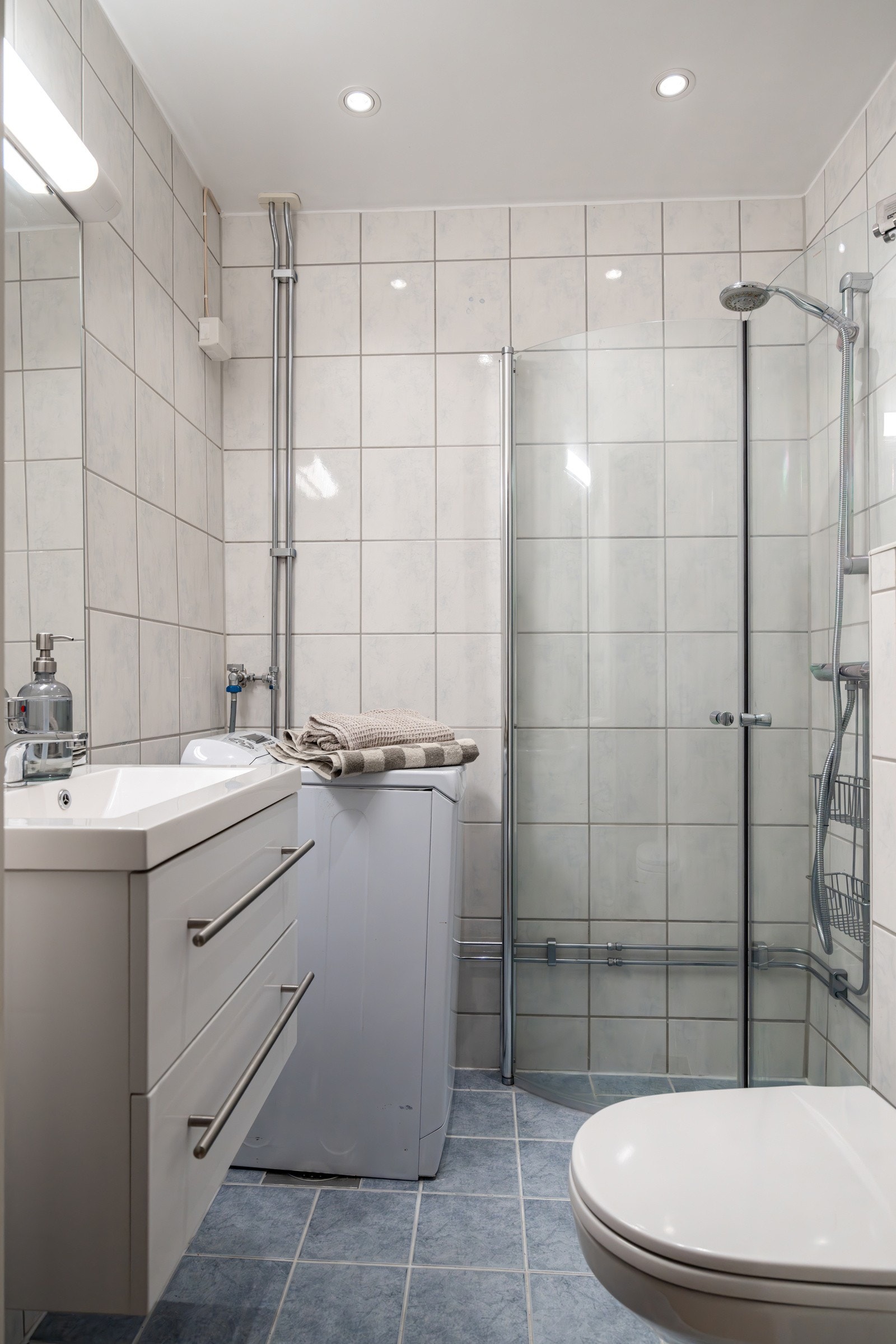 Flislagt baderom med varme i gulv og opplegg for vaskemaskin. Galleribilde