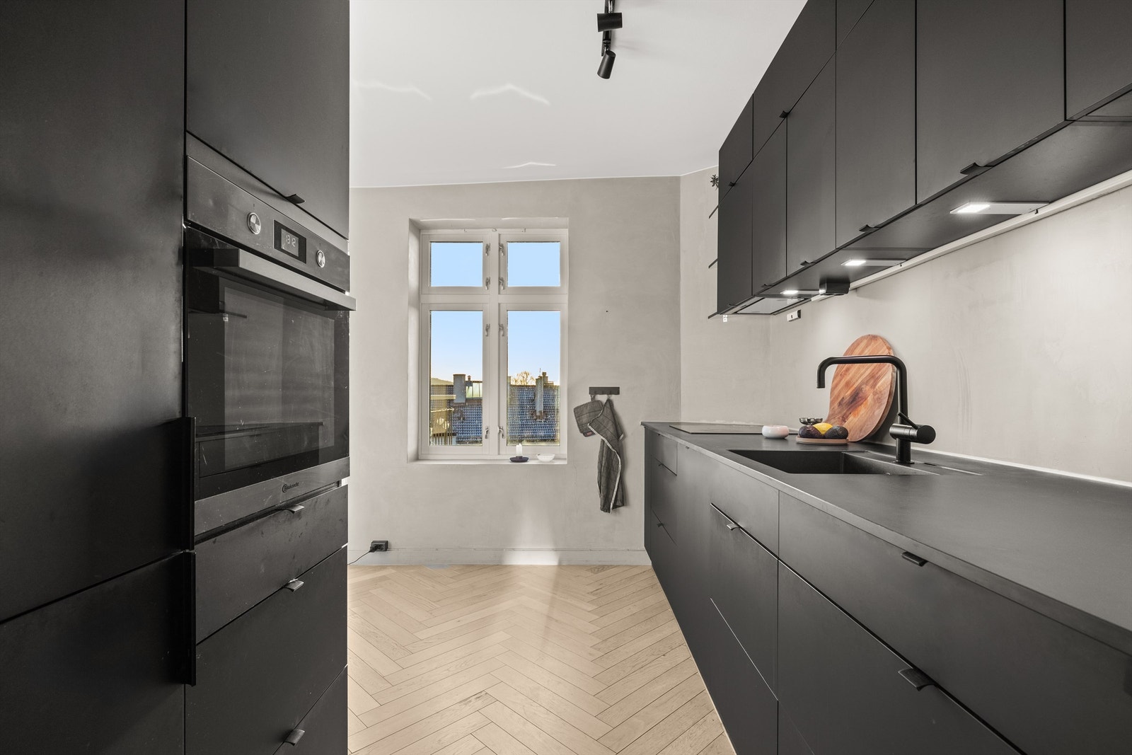 Hvitevarene er sømløst integrert i innredningen og består av komfyr, platetopp, oppvaskmaskin og kombinert kjøleskap/fryser Galleribilde