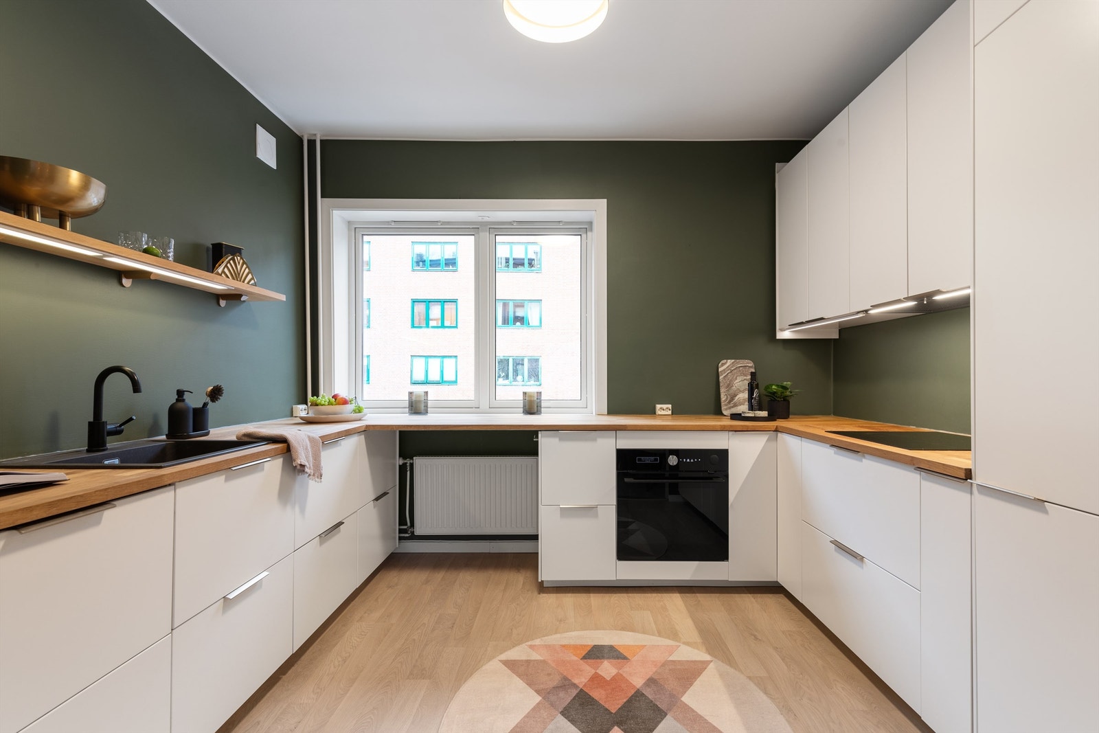 Det er rikelig med oppbevaringsplass i både skuffer og takhøye skap. Den gode benkeplassen gjør det enkelt å diske opp lekre middager. Galleribilde