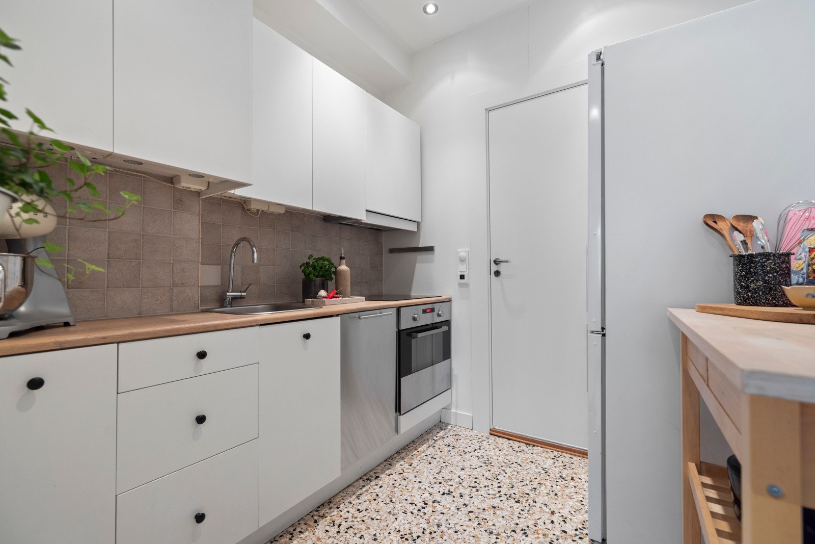 Integrert platetopp og stekeovn, opplegg for oppvaskmaskin og plass til kjøle/fryseskap. Dør rett frem tar deg til baderommet. Galleribilde