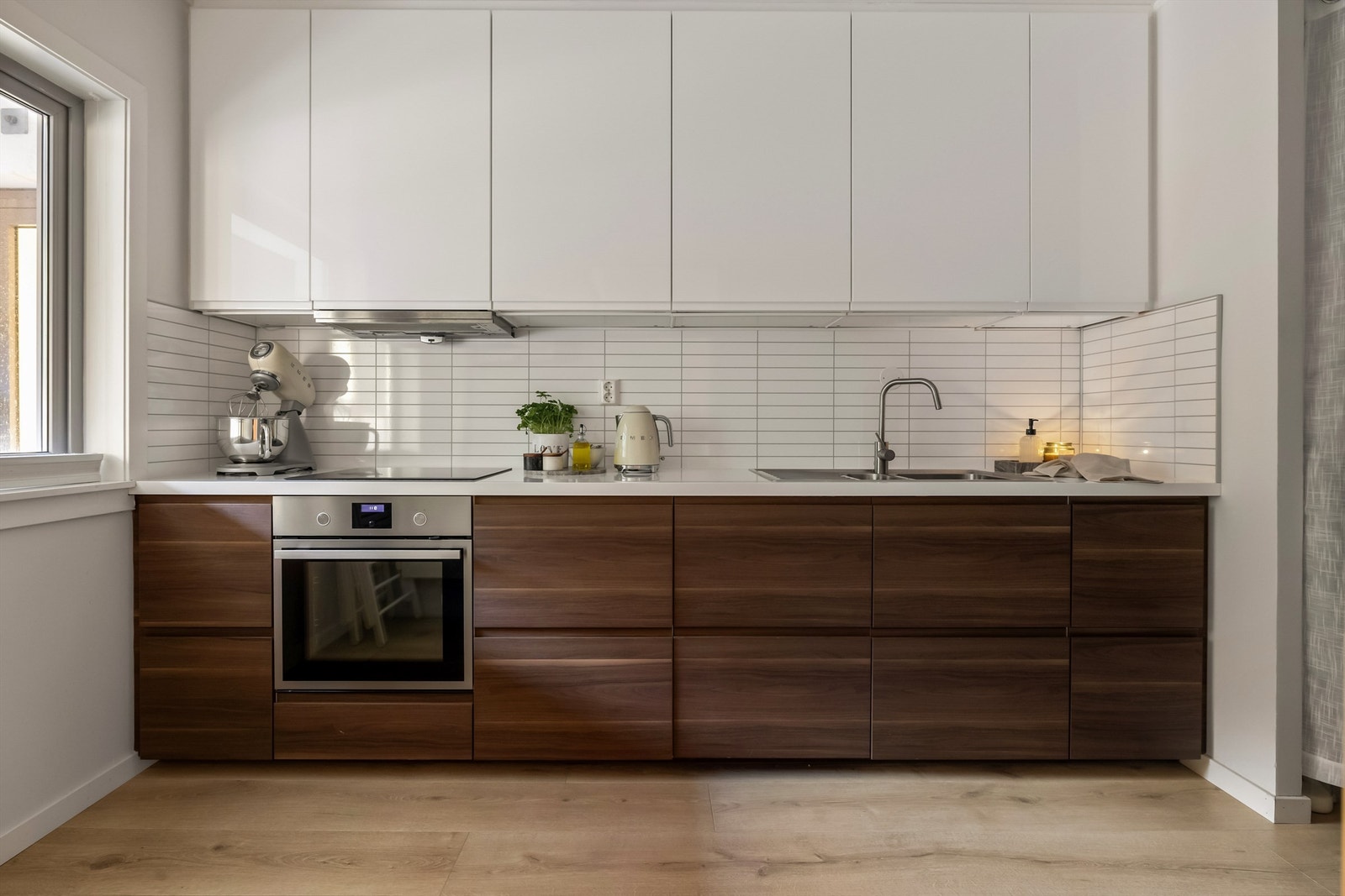 Nytt kjøkken med stilrene og slette flater som flyter fint inn med resten av leiligheten. Galleribilde