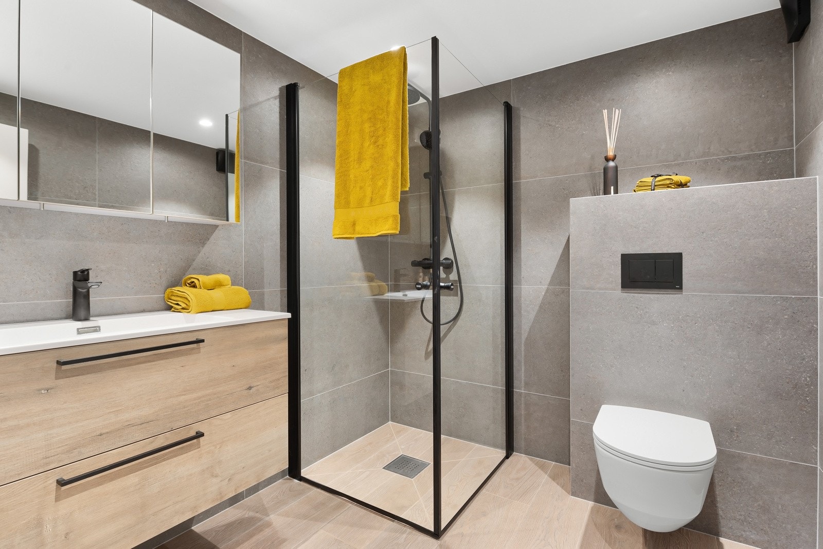 Badet har tidløse fliser og er innredet med servantskap, dusjhjørne og vegghengt wc. Galleribilde