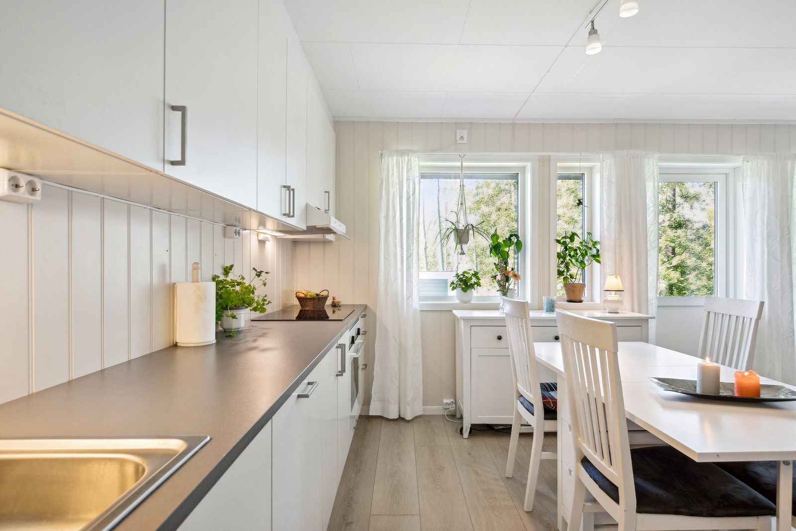 Kjøkkenet har innredning med glatte fronter og en slitesterk benkeplate av laminat. Galleribilde