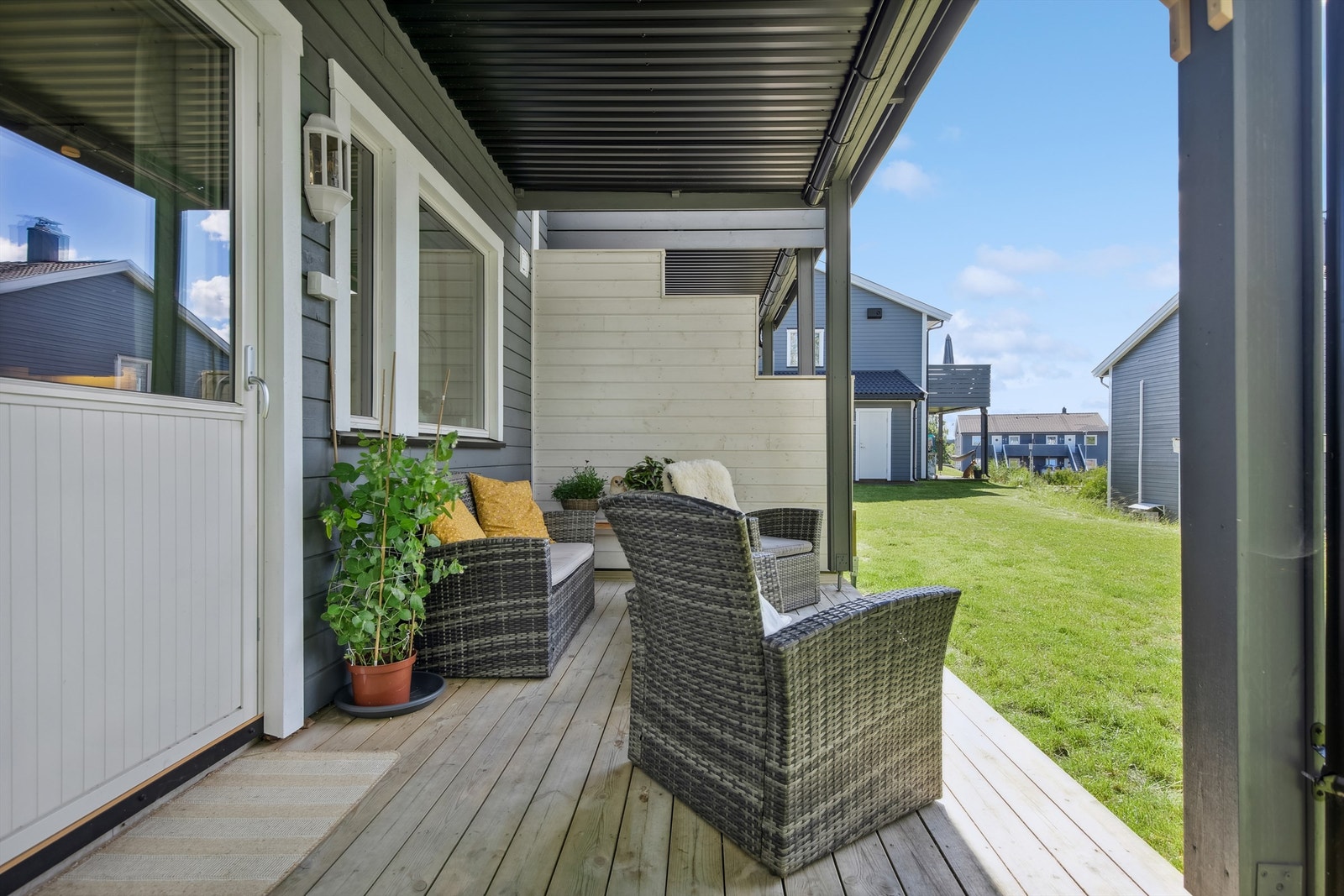 Takoverbygget terrasse utenfor stuen mot et stille og rolig nabolag. Galleribilde