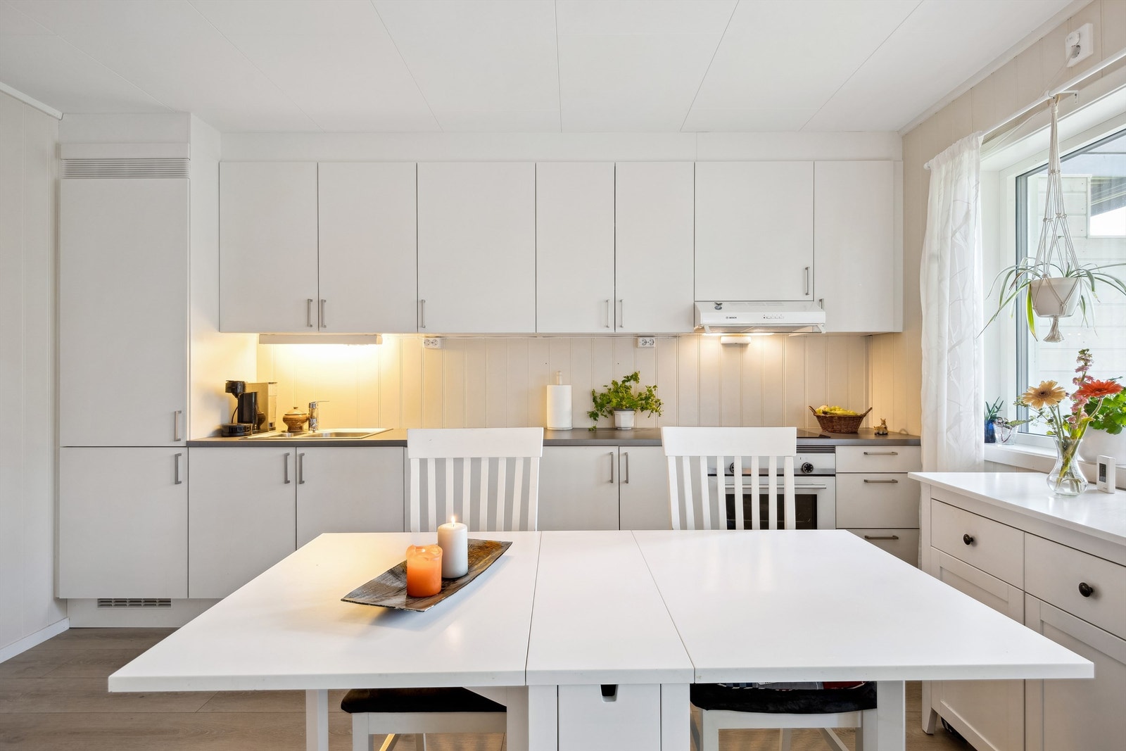 Lyst og stilrent kjøkken med innholdsrik innredning. Galleribilde