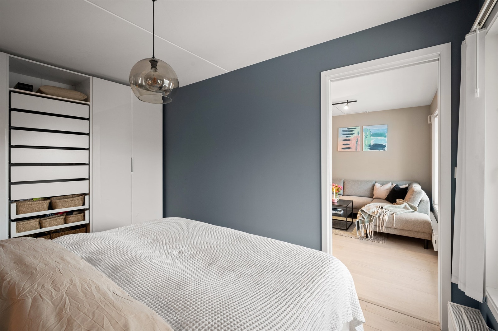 Eikeparkett på gulvet og veggene er malt i en lun farge som sammen gir en deilig atmosfære å sove i Galleribilde