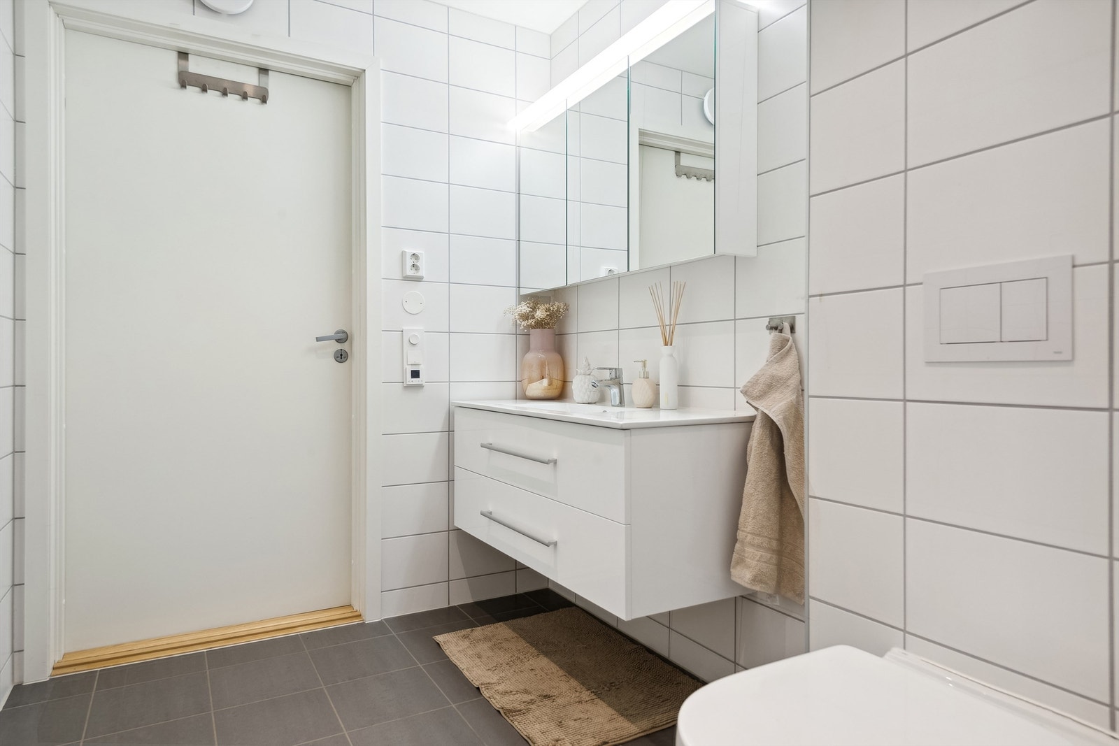 Leiligheten har et delikat, flislagt bad som også fungerer som vaskerom, Gulvet og veggene er flislagt og det er varmekabler i gulv. Galleribilde