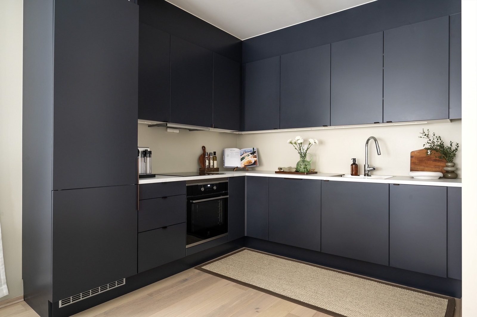 Moderne og stilrent kjøkken fra HTH. Innredningen består av glatte fronter, laminat benkeplate med nedfelt vask. Hvitevarene er sømløst integrert med platetopp, stekeovn, oppvaskmaskin og kjøl/fryseskap. Avtrekk over kokeplass. Galleribilde