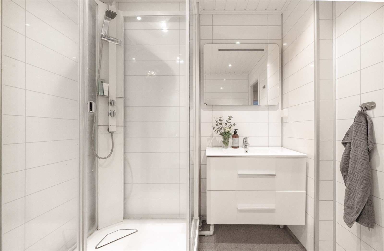 På badet er det våtromsplater på vegger, malt trepanel i tak og belegg på gulvet med varmekabler. Galleribilde