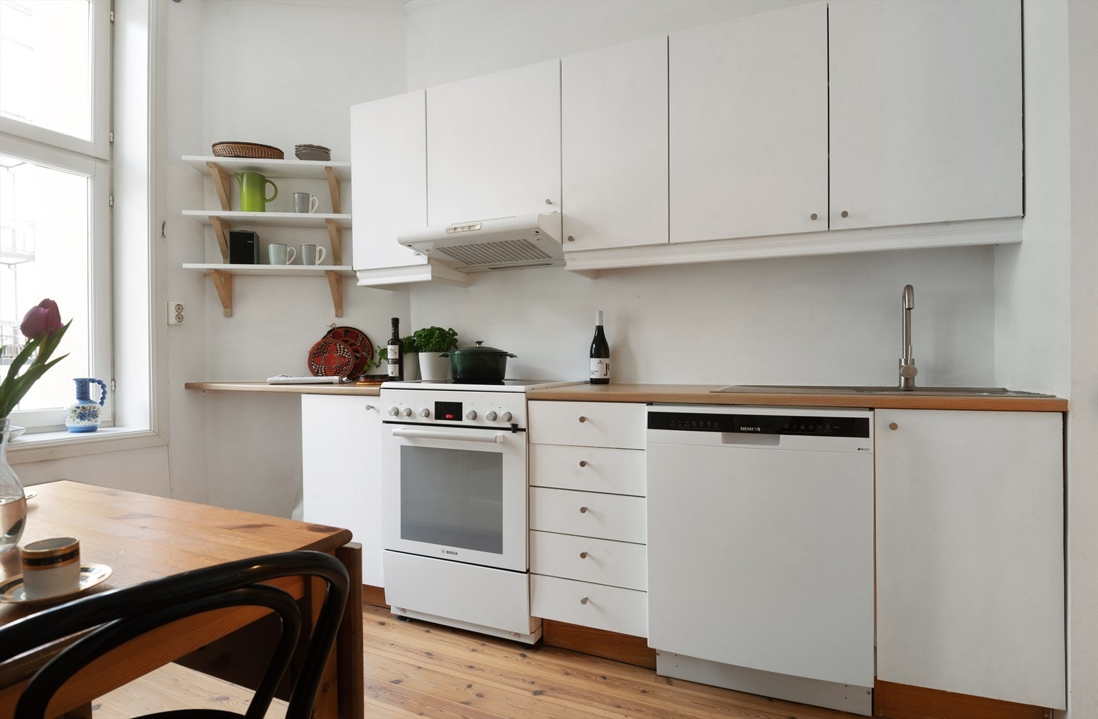 Lyst kjøkken med glatte fronter og foliert benkeplate. Galleribilde