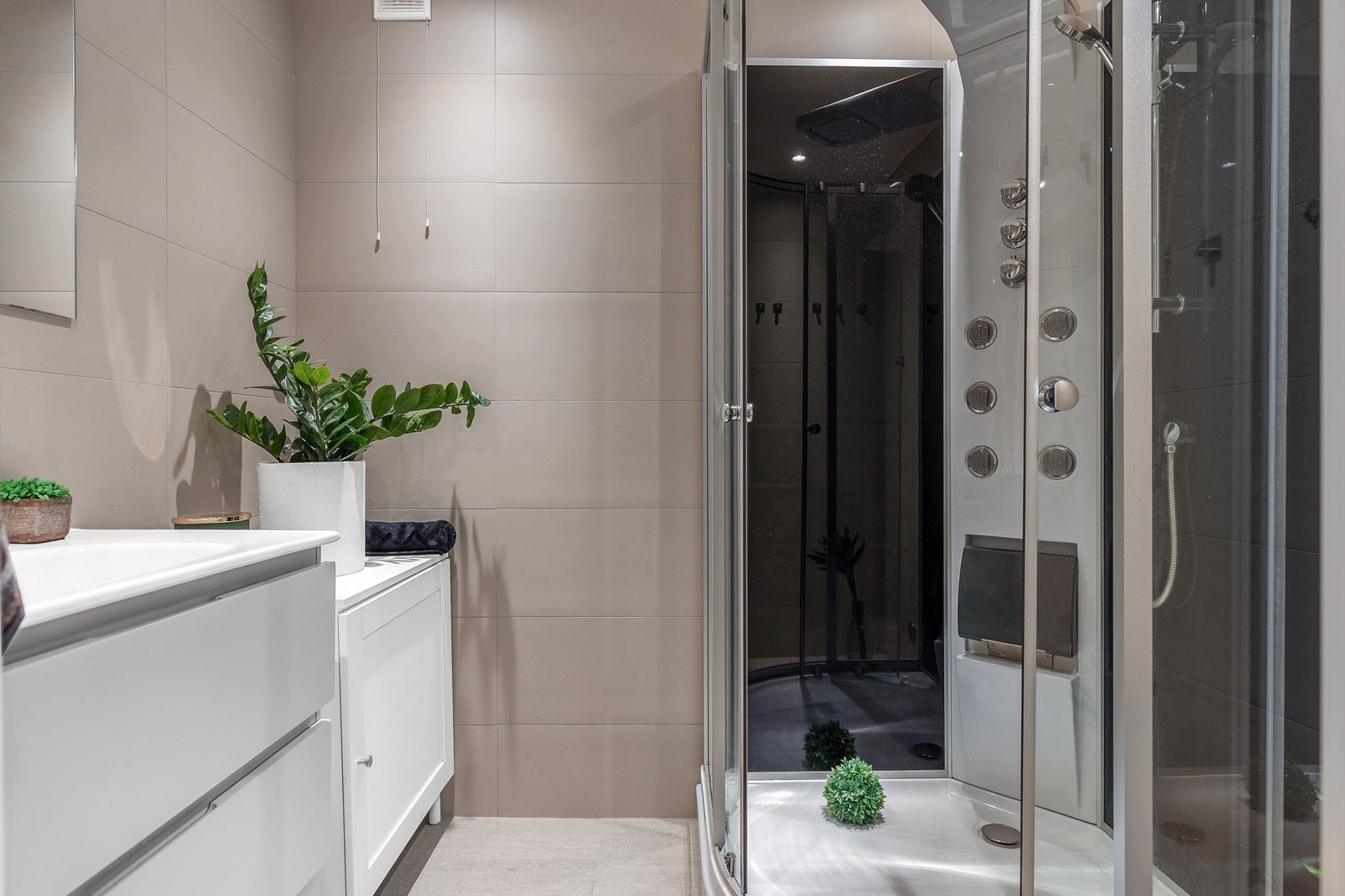 Badet er stilfullt og tidløst med pent flisbelagte gulv og vegger, med elektrisk varme i gulvet. Hele badet ble pusset opp i 2019, og er innredet med servantinnredning med nedfelt servant, dusjkabinett, og det er opplegg for vaskemaskin. Galleribilde