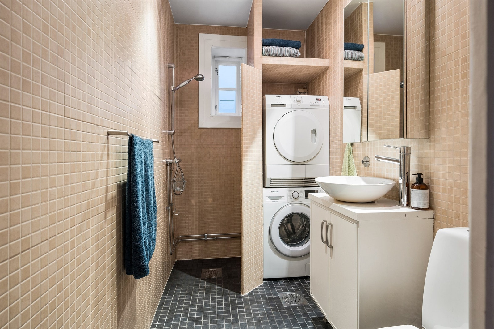 Det er gulvvarme på badet og her er det opplegg for vaskemaskin og tørketrommel. Galleribilde