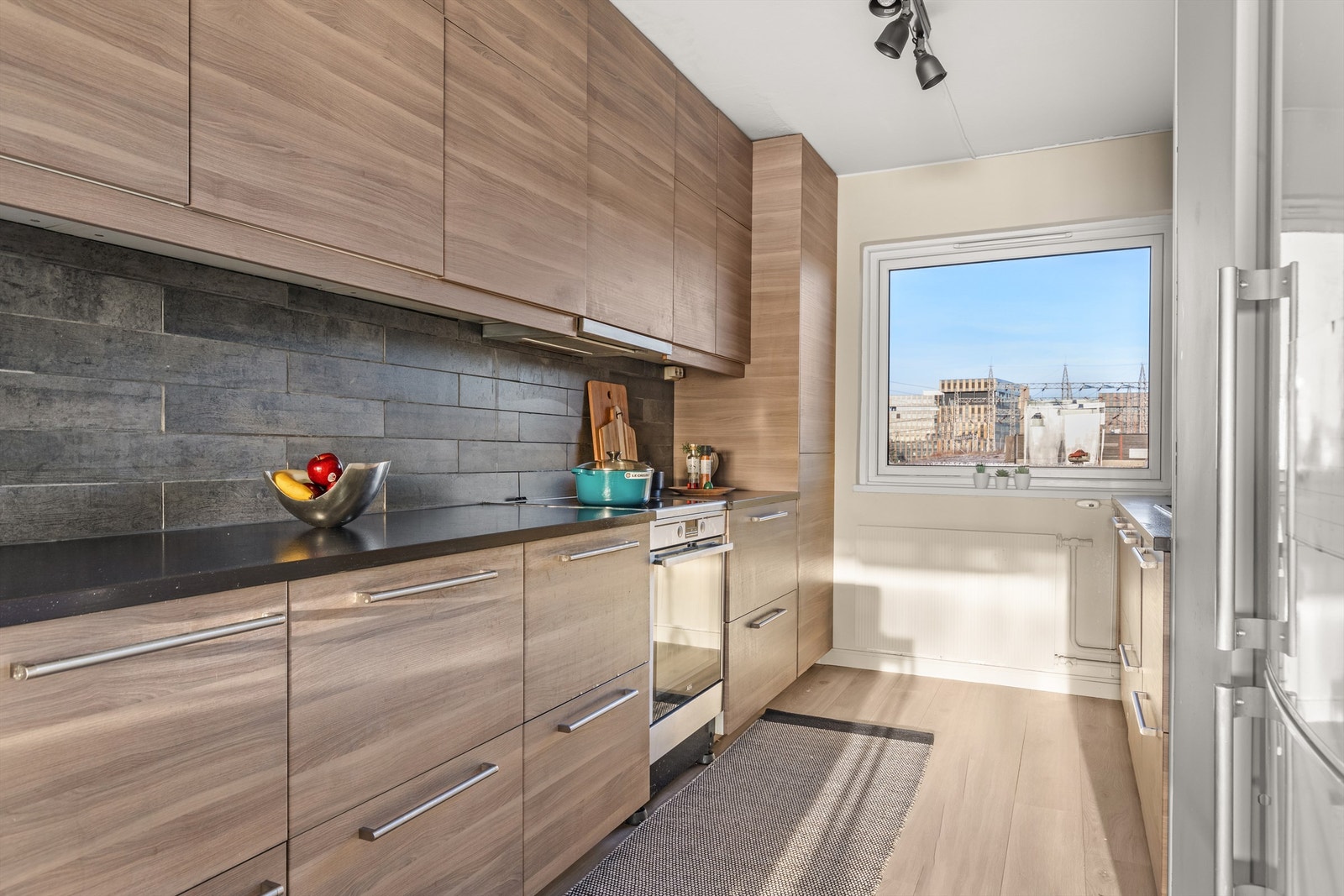 Leilighetens kjøkken er holdt i en sosial, åpen løsning mot stuen, noe som skaper et naturlig samlingspunkt i leiligheten. Galleribilde