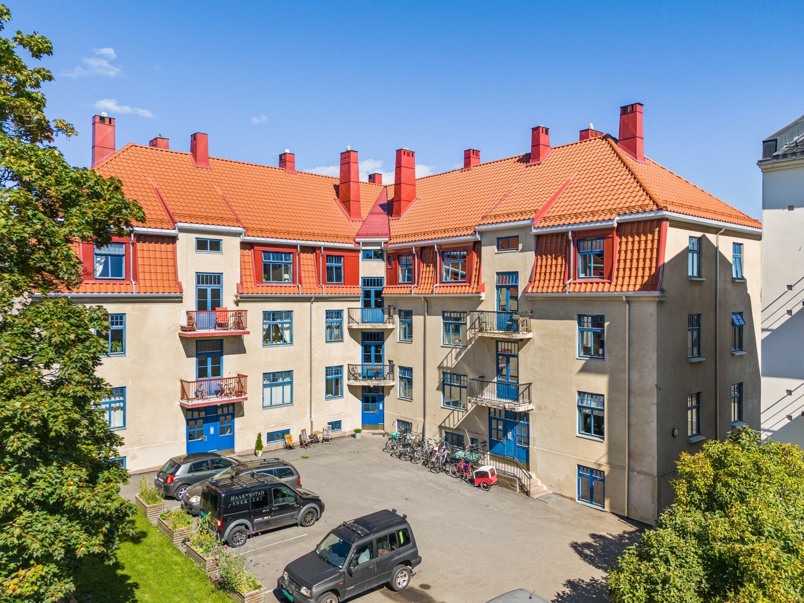 Asfaltert bakgård med noe biloppstillingsplasser. Galleribilde