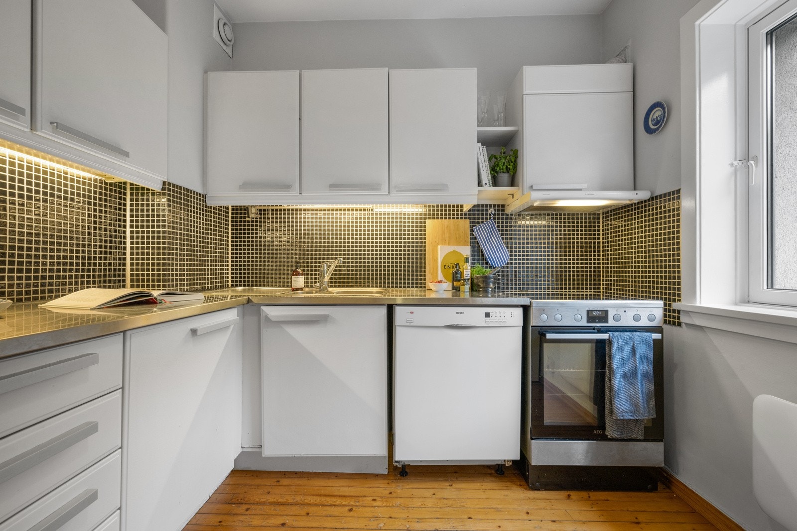 - Kjøkkeninnredning med hvite slette fabrikklakkerte fronter, platebeslått benkeplate m/fliser over, 1 1/2 oppvaskkum og ventilator - Galleribilde