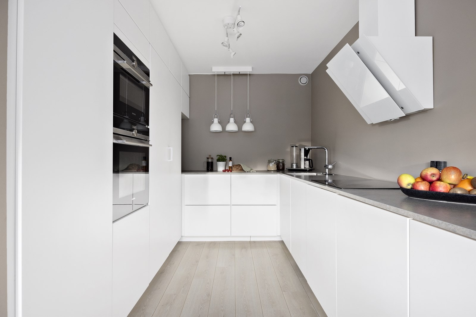 Innbydende kjøkken med glatte, folierte fronter med laminat benkeplate Galleribilde