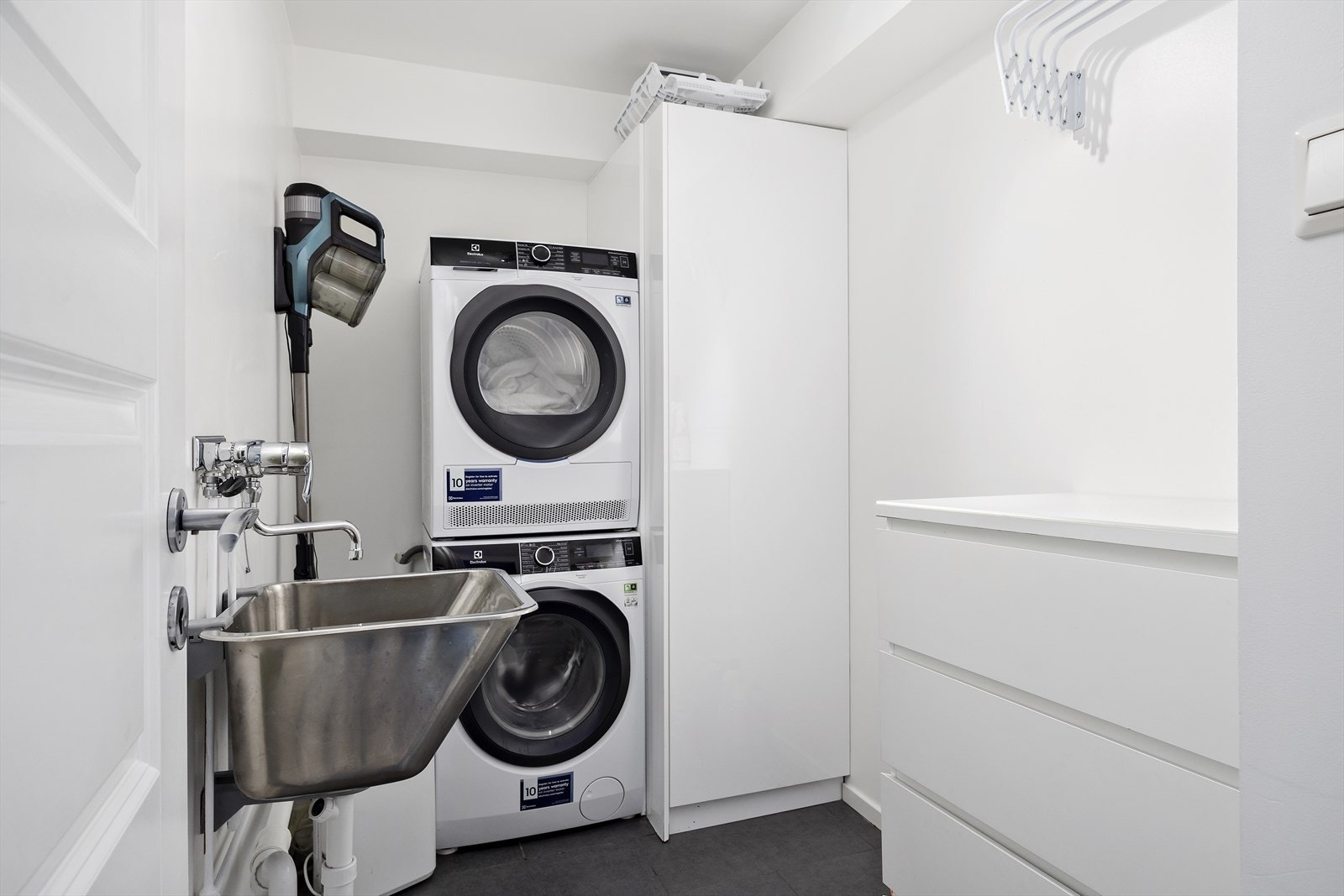 Eget vaskerom med opplegg for vaskemaskin og tørketrommel samt oppbevaring Galleribilde