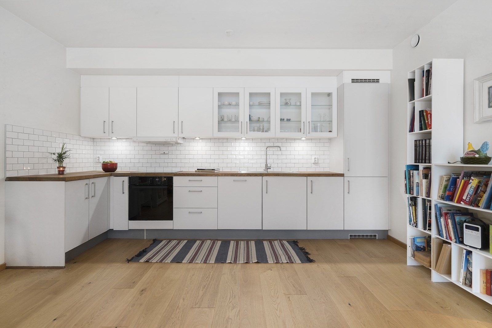 Kjøkkeninnredningen er moderne med lyse, glatte fronter og en heltre benkeplate. Galleribilde