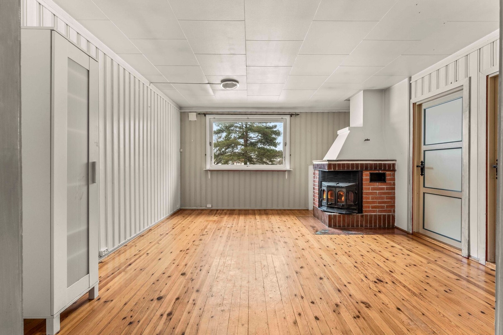 Boligen er delt i flere stuer og mange gode soner. Her med en peisstue Galleribilde