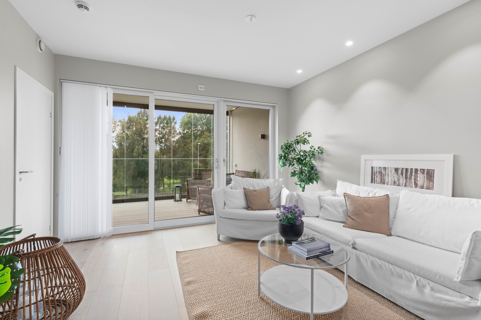 De store vindusflatene i stua slipper inn rikelig med sollys og lyser leiligheten behagelig opp Galleribilde