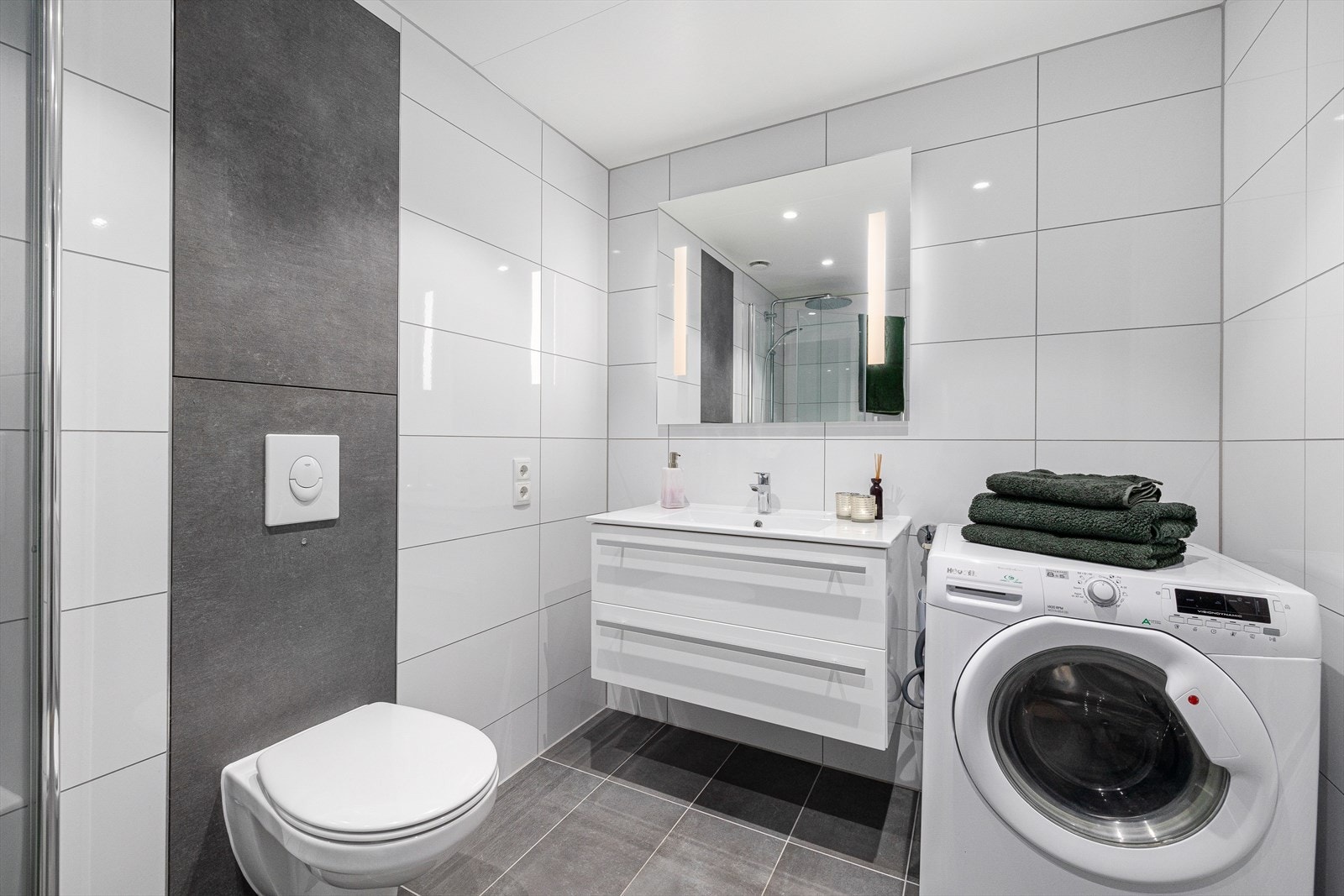 Innredet med dusjhjørne, møbel m/servant, speil m/lys, vegghengt klosett og opplegg til vaskemaskin. Mekanisk avtrekk. Galleribilde