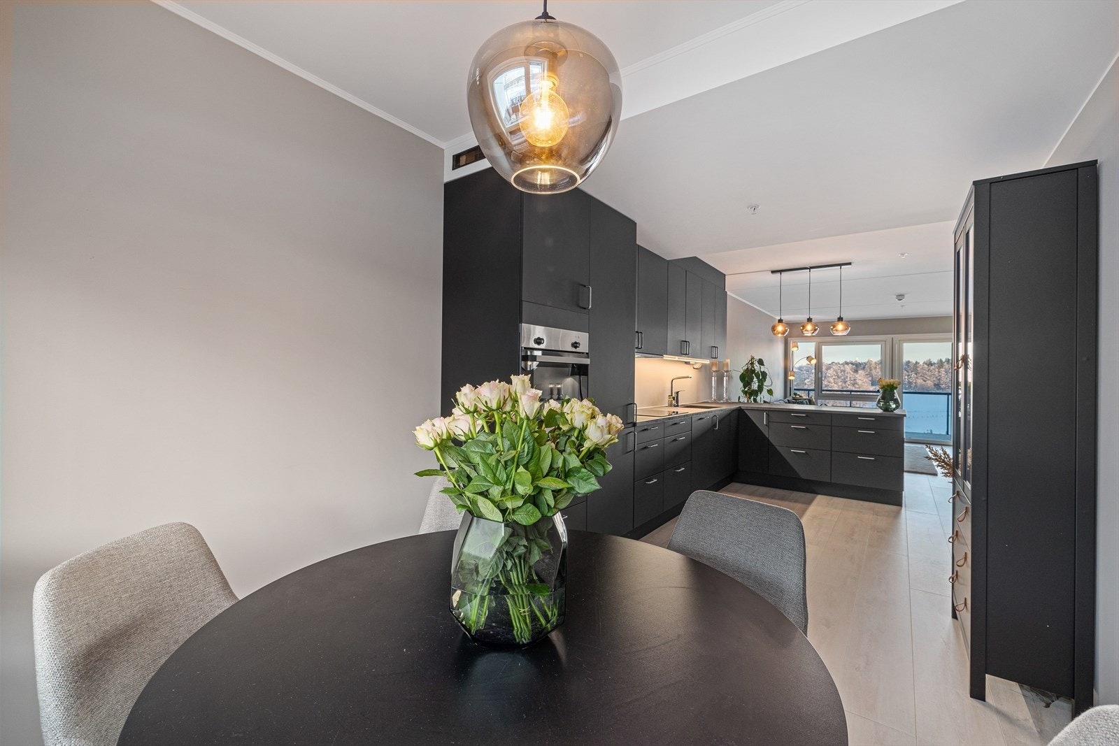 Fra kjøkkenet kan man holde samtalen i gang med familie eller gjester som har funnet seg til rette ved spisebordet. Galleribilde