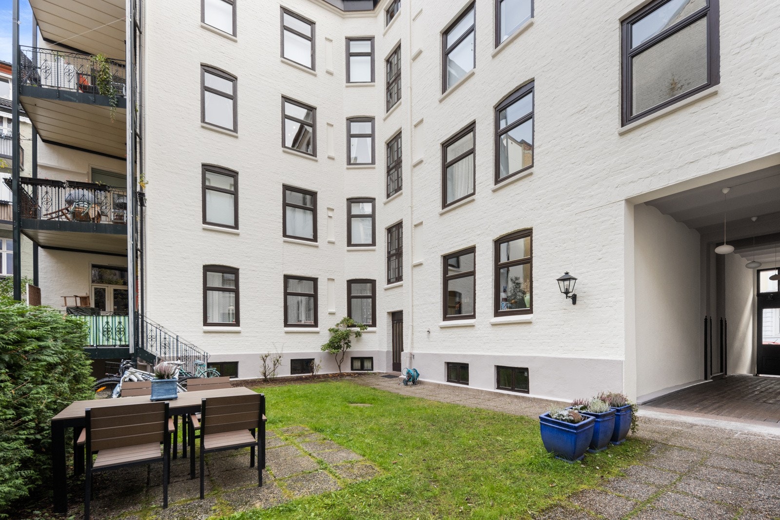 Hyggelig grøntareal i bakgården med beplantning og sittegruppe. Galleribilde