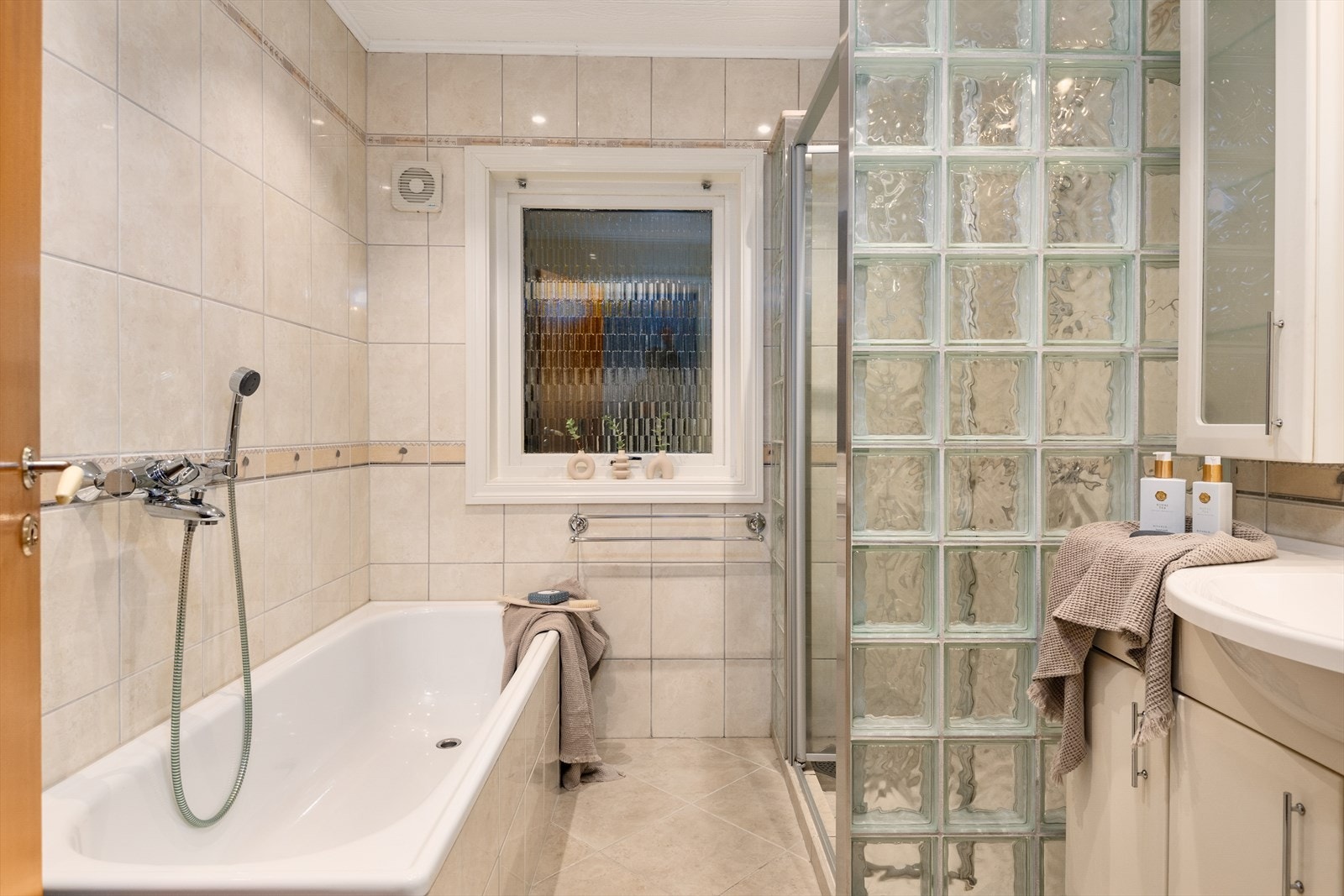 Flislagt baderom med varmekabler, badekar og dusjhjørne Galleribilde