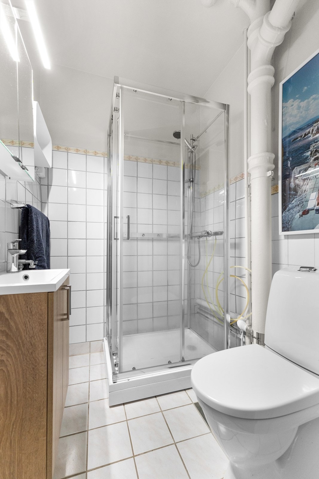 Benkeskap med glatte fronter, overskap med speilfronter og opplegg for vaskemaskin. Galleribilde