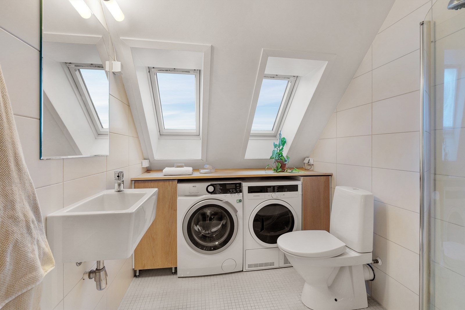 Delikat flislagt baderom med varmekabler i gulv. Rommets vegger og gulv er belagt med fine fliser, og takvinduene sørger for at man får rikelig med naturlig lys inn i rommet. Galleribilde