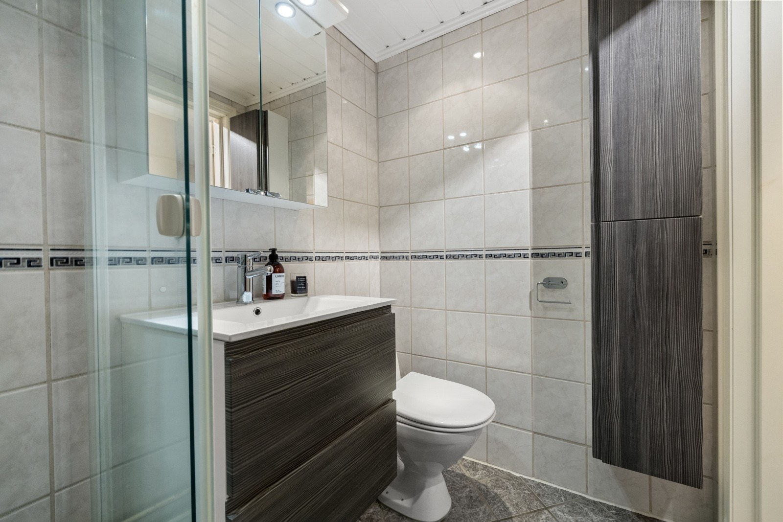 Badet har god plass til oppbevaring med servantskap, veggskap og speilskap. Galleribilde