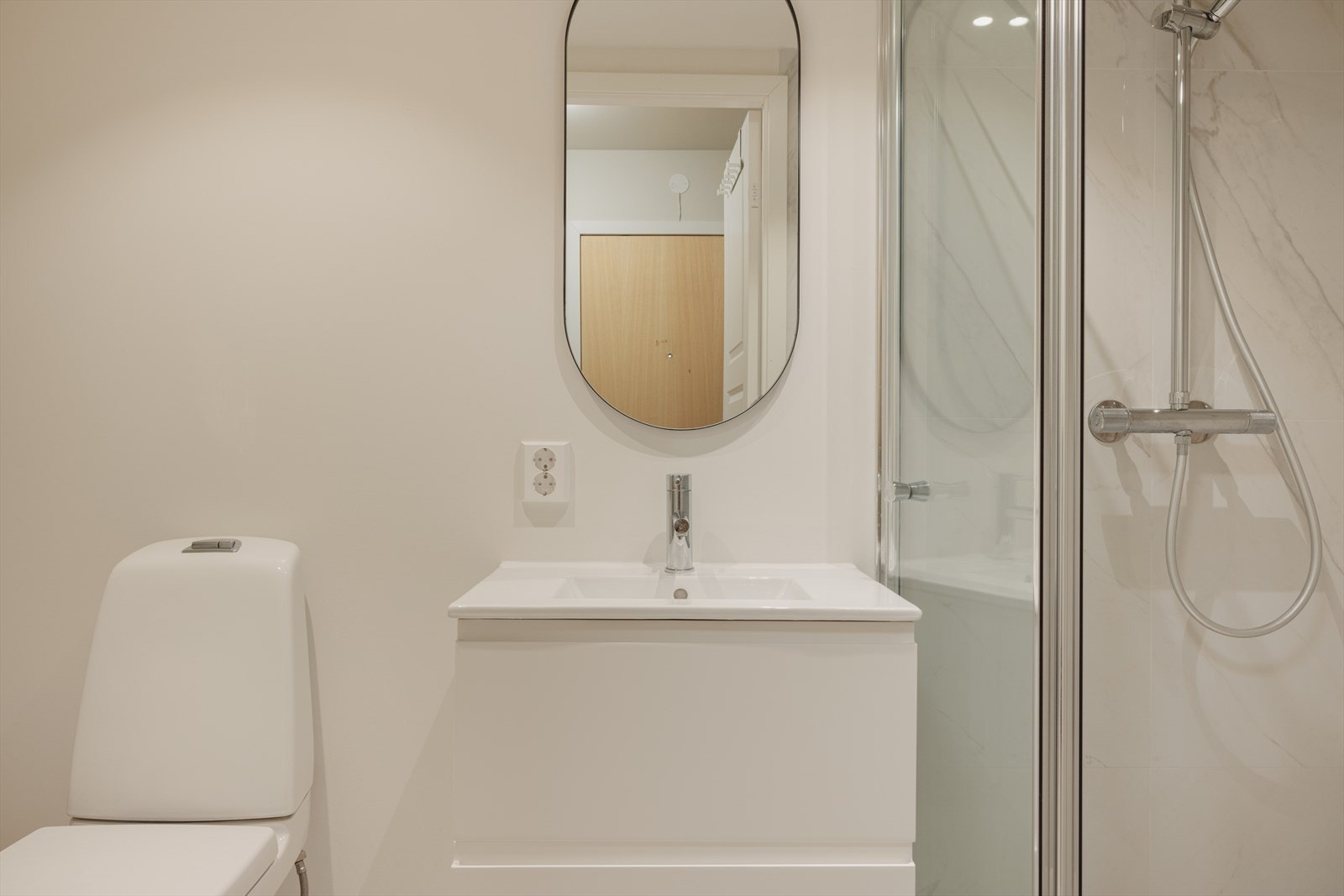 Badet har i likhet med resten av leiligheten blitt oppgradert i 2024. Badet inneholder dusj, toalett og servant. Badet er gjennomført med en elegant design og moderne detaljer som gir rommet et stilrent og moderne uttrykk. Galleribilde