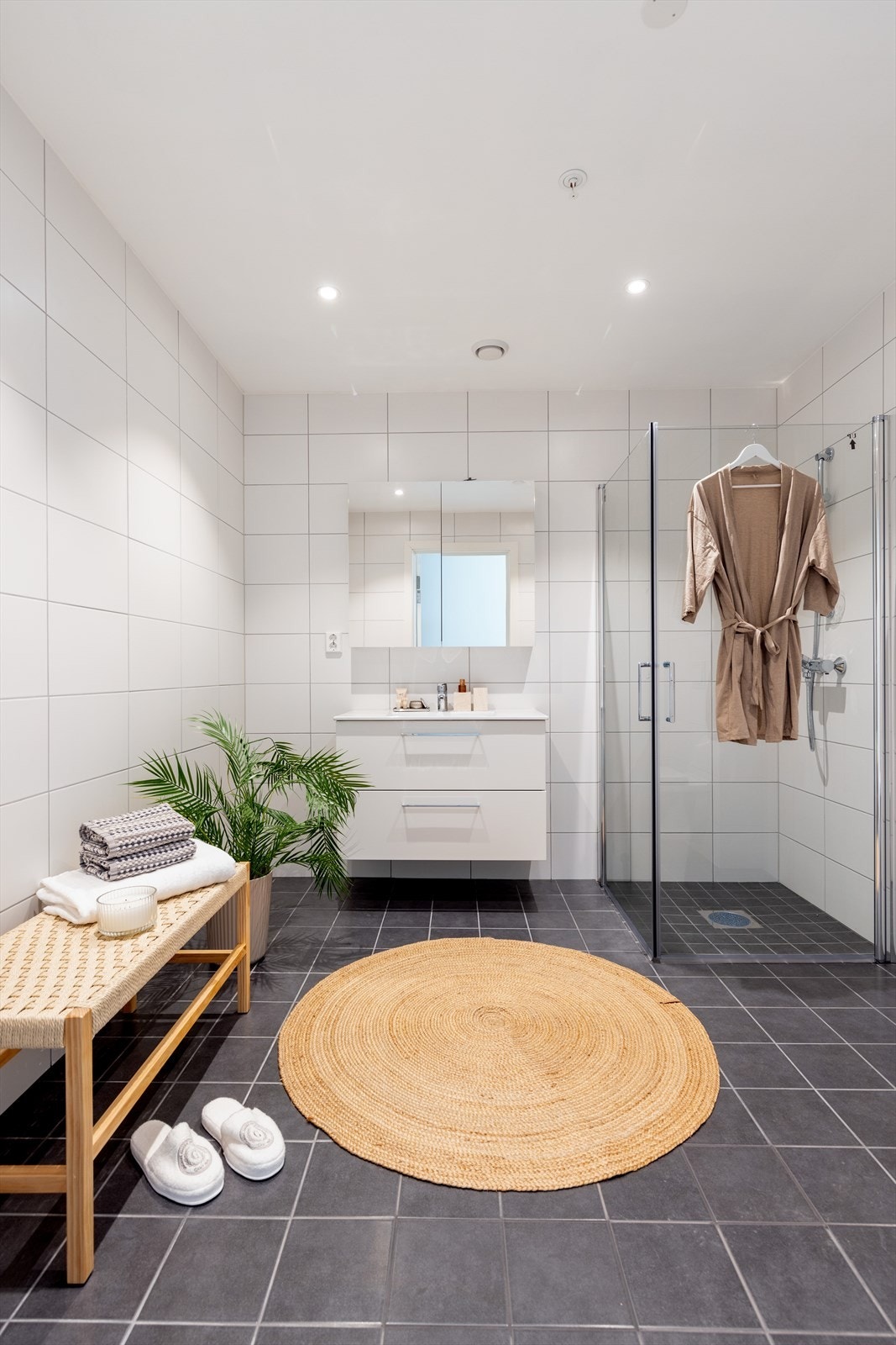 Stilrent, flislagt bad med moderne innredning. Innredning har praktisk skuffeløsning med heldekkende servant og speilskap. Videre er det praktisk dusjnisje med dører og vegghengt toalett. Galleribilde