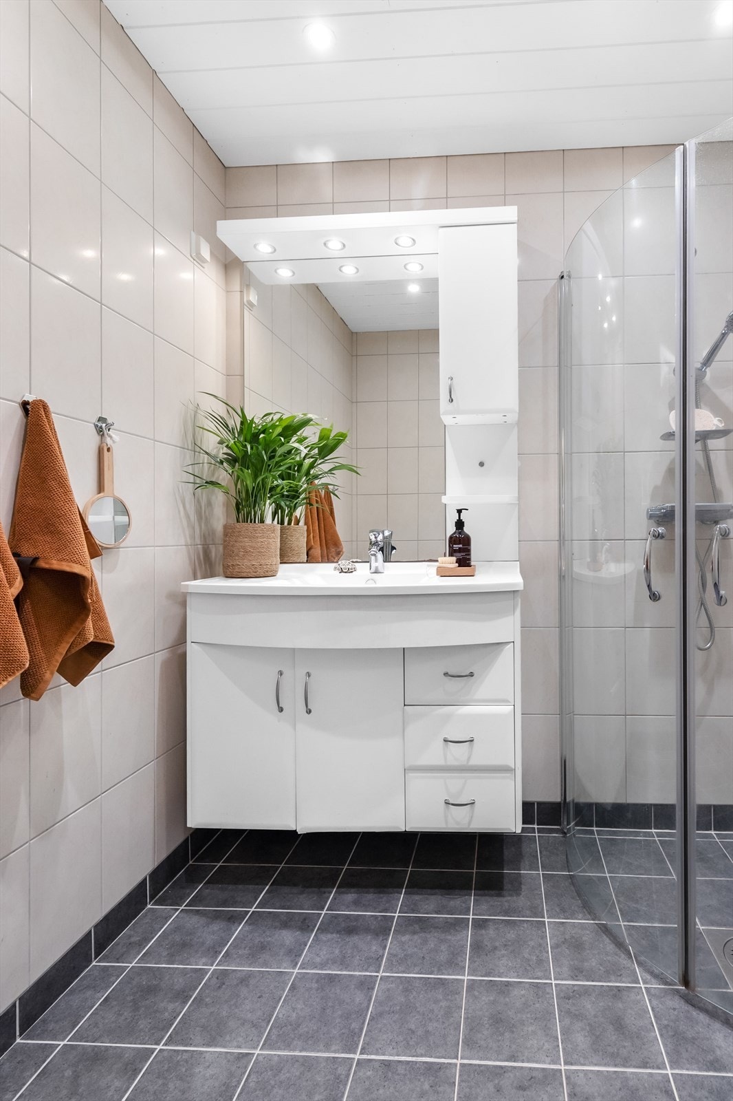 Av innredning er det vegghengt servantskap med ovenpåliggende servant, speil med belysning og dusjhjørne med innfellbare glassdører. Galleribilde