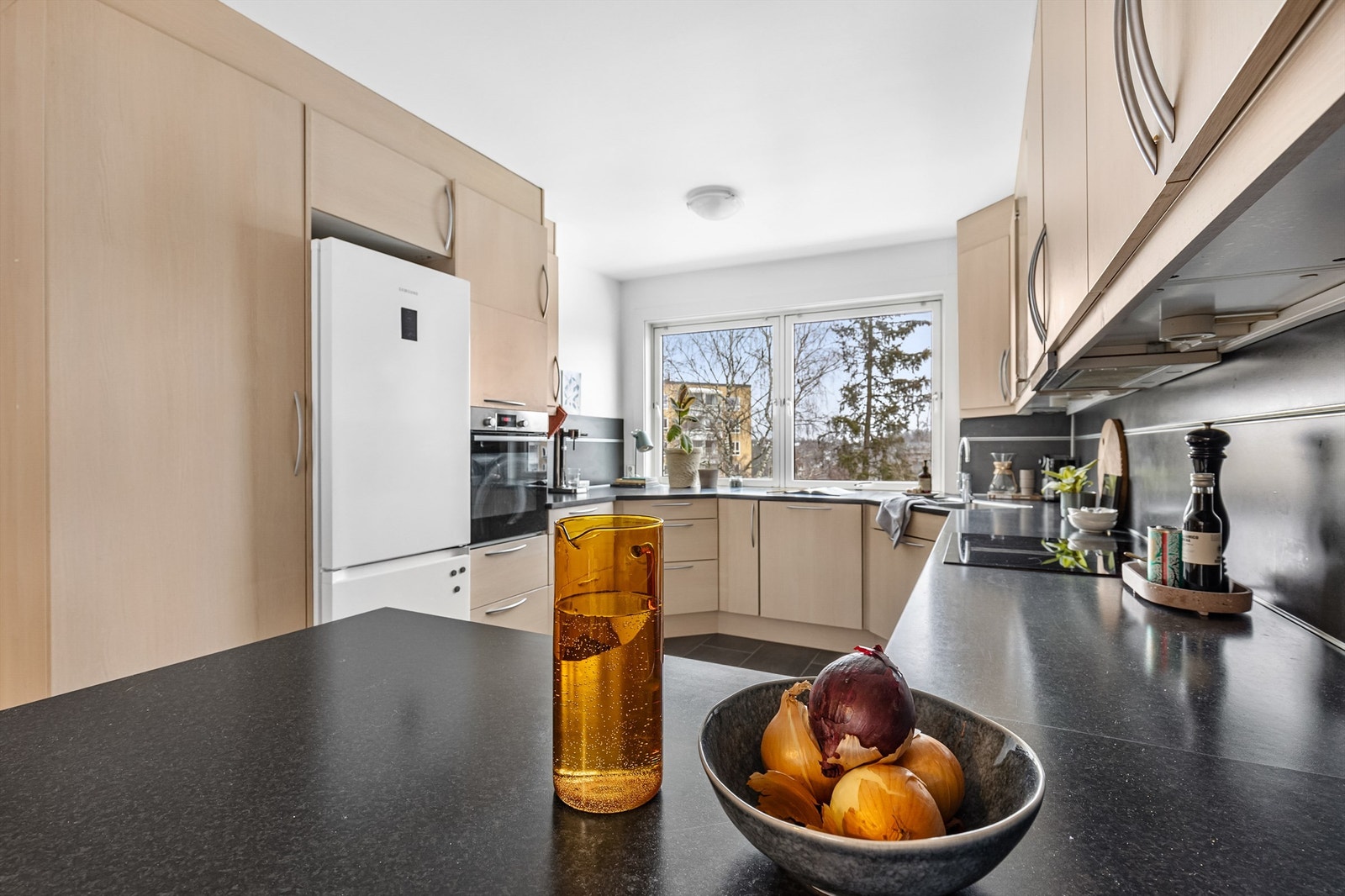 Kjøkkenet er stort og luftig med benkeplate i laminat, slette fronter, oppvaskkum i rustfritt stål og benkskapsbelysning. Galleribilde