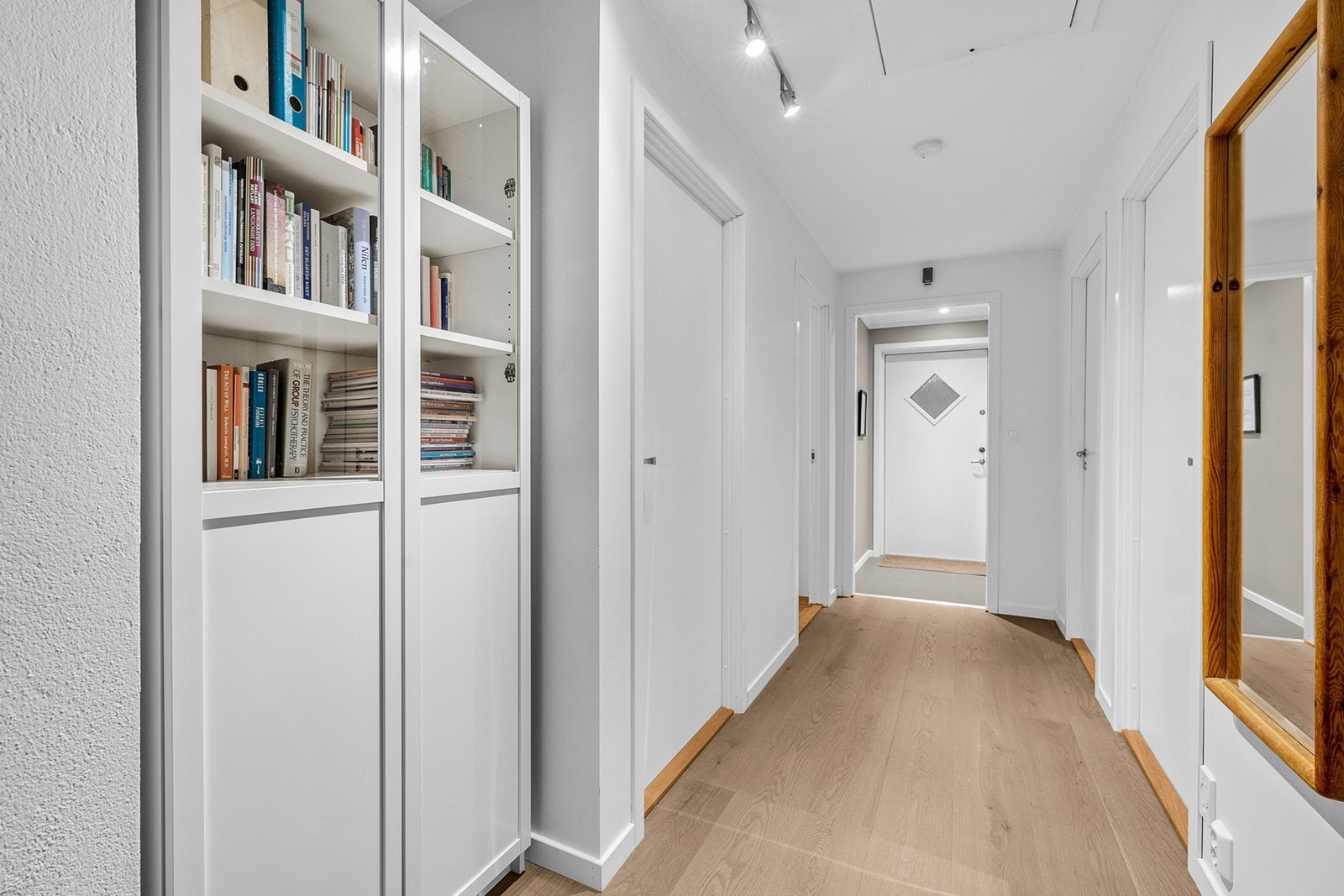 En innbydende entré med flislagt gulv med gulvvarme, malte flater, downlights i himling. Her er det plass til yttertøyet med knagger, skohylle og speil. Videre innover en gang med ytterligere oppbevaringsplass, samt en bod tilknyttet gangen. Galleribilde