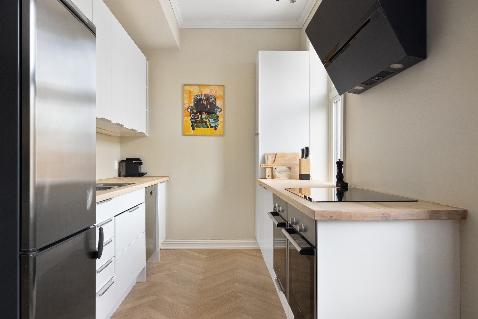 Kjøkkeninnredning fra 2013 med slette fronter og benkeplater av treverk. Galleribilde