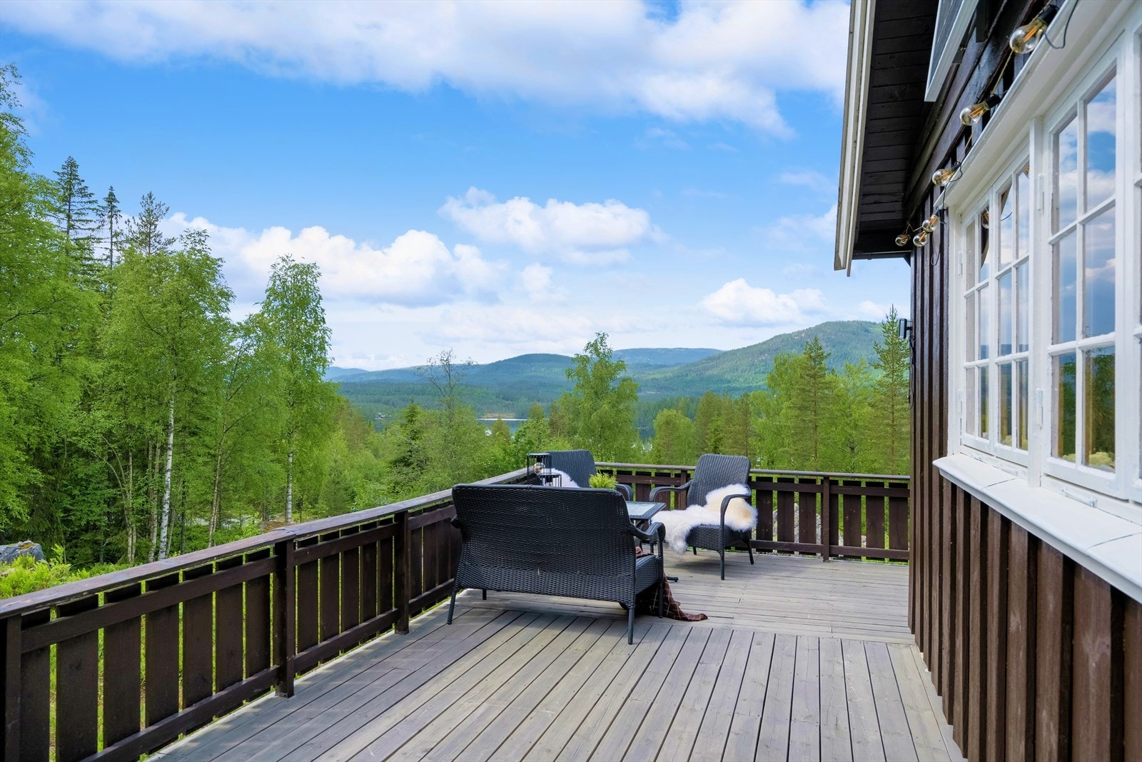 en romslige og solrike terrassen strekker seg rundt to sider av hytten, og mot vest kan du nyte en fantastisk utsikt mot fjellene i horisonten Galleribilde