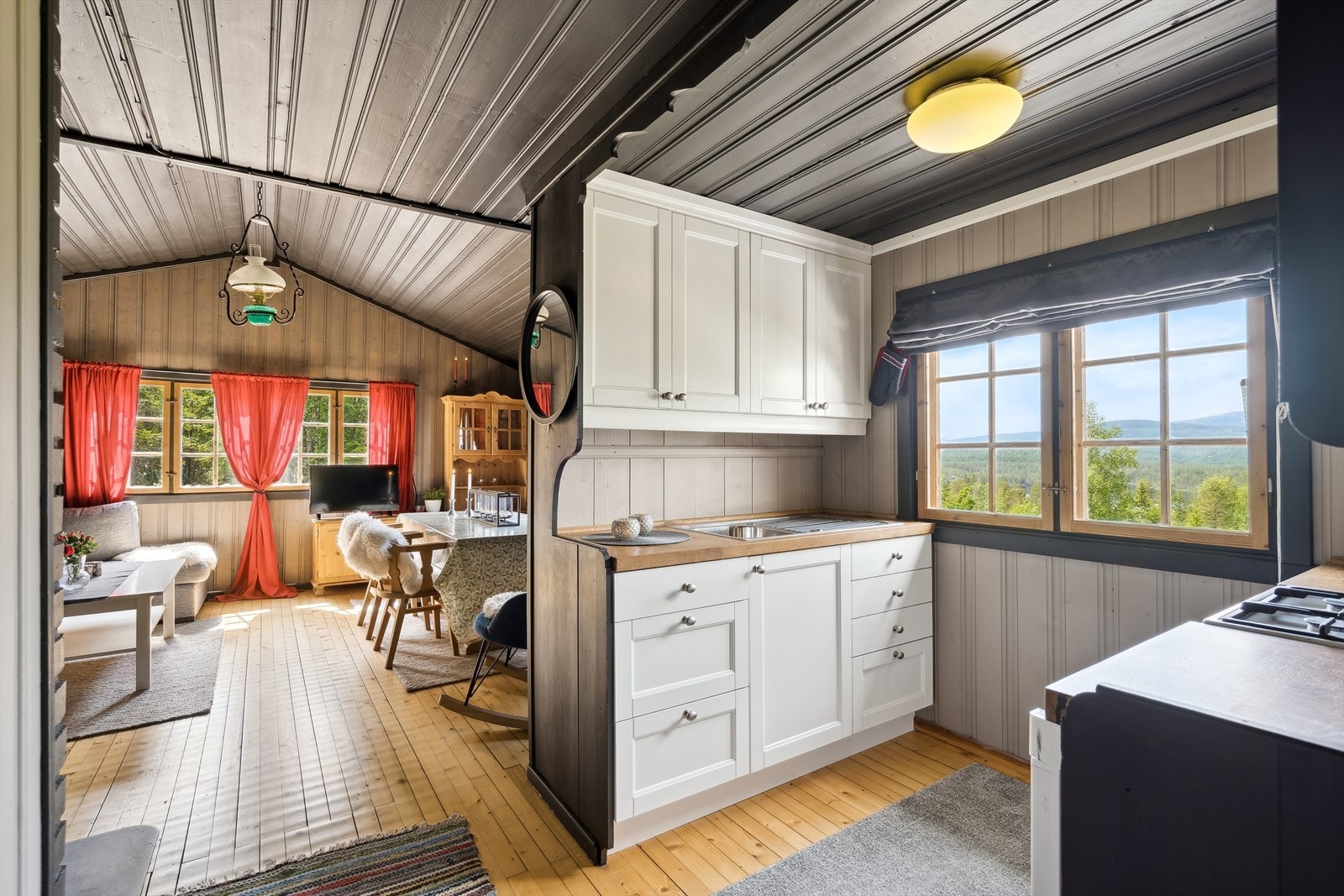 Kjøkkenet ligger i en åpen løsning og er utstyrt med både kjøleskap og gasskomfyr, noe som gjør det perfekt for matlaging og sosiale sammenkomster Galleribilde