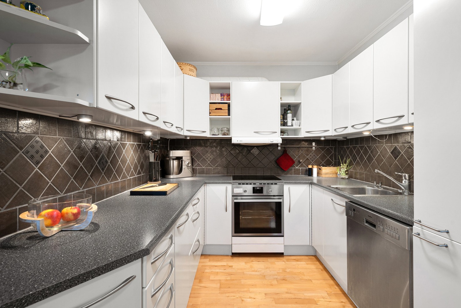 Flott kjøkken med fliser over benkeplate. Galleribilde