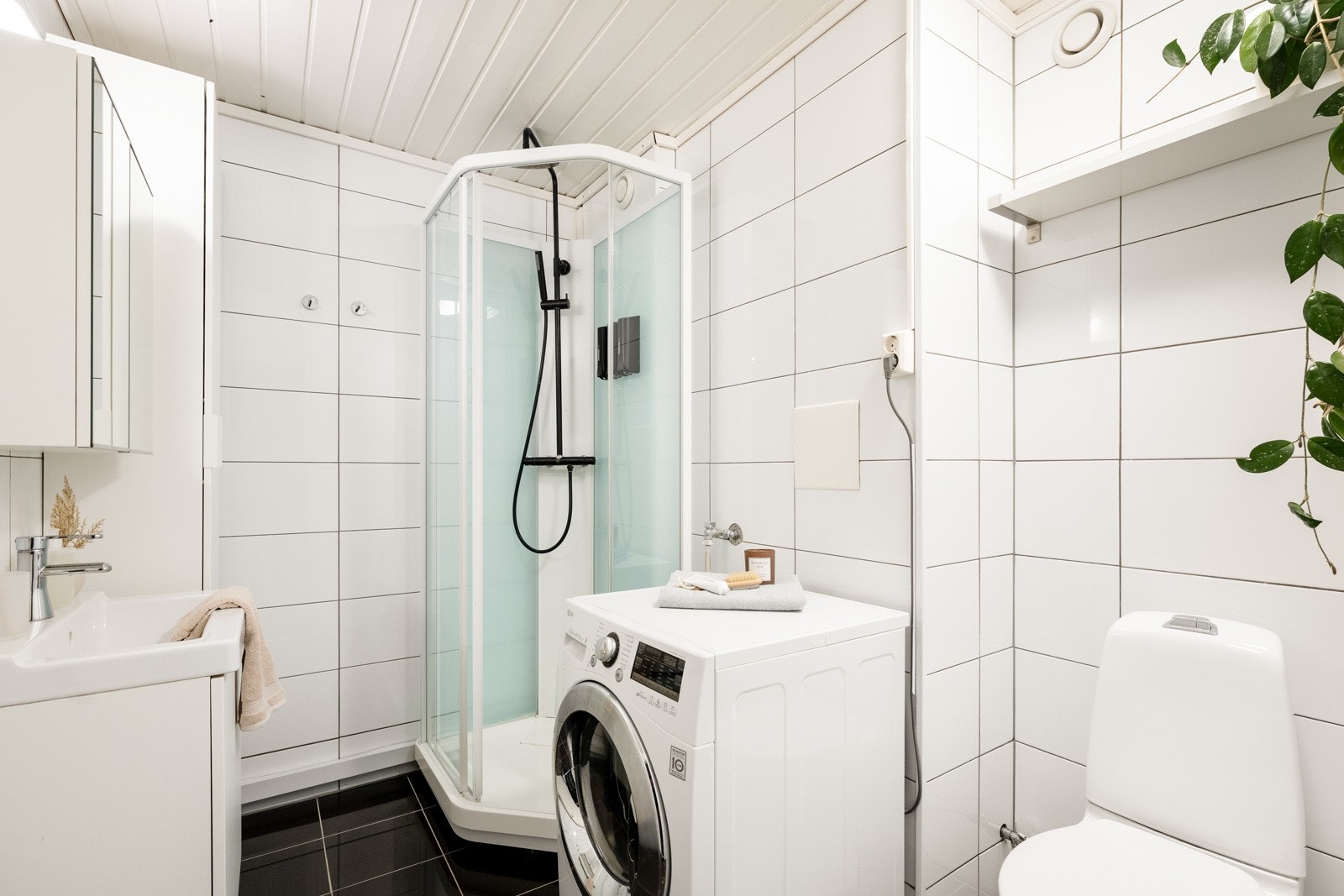 Badet ble pusset opp i 2013, og rommet har hvite veggfliser og sorte gulvfliser for en fin kontrast Galleribilde