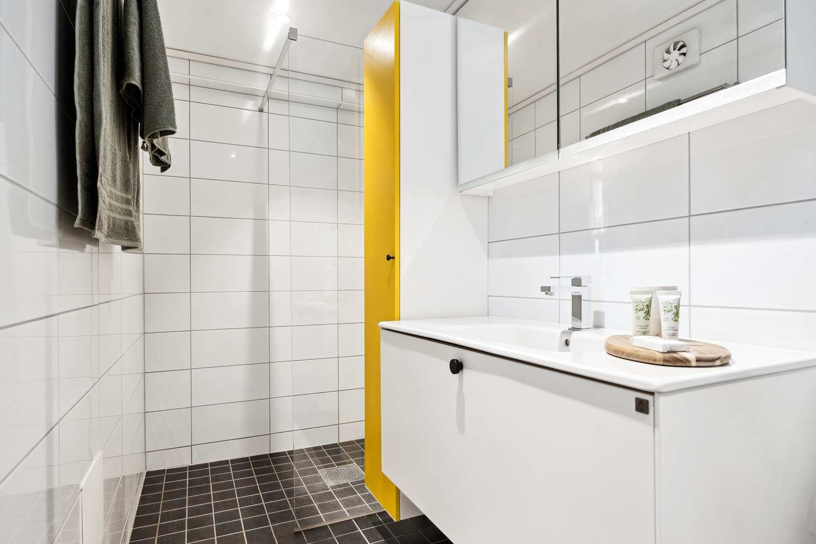 Lyst og flislagt baderom med gulvvarme og downlights i himlingen, som gir et moderne og innbydende preg. Galleribilde