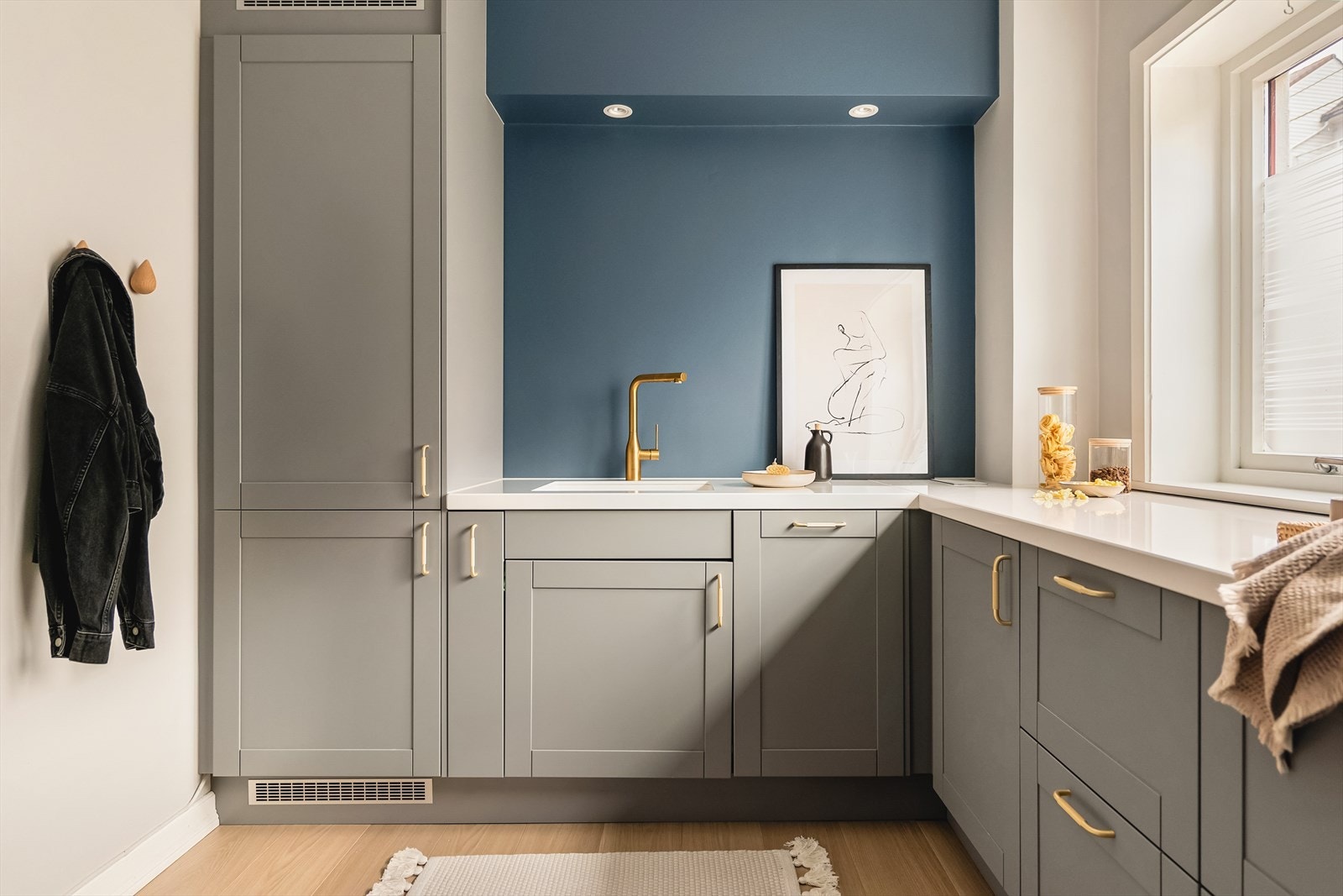 Kjøkken har en fin benkeplate i hvitfarge som går godt med lyset fra vinduene Galleribilde