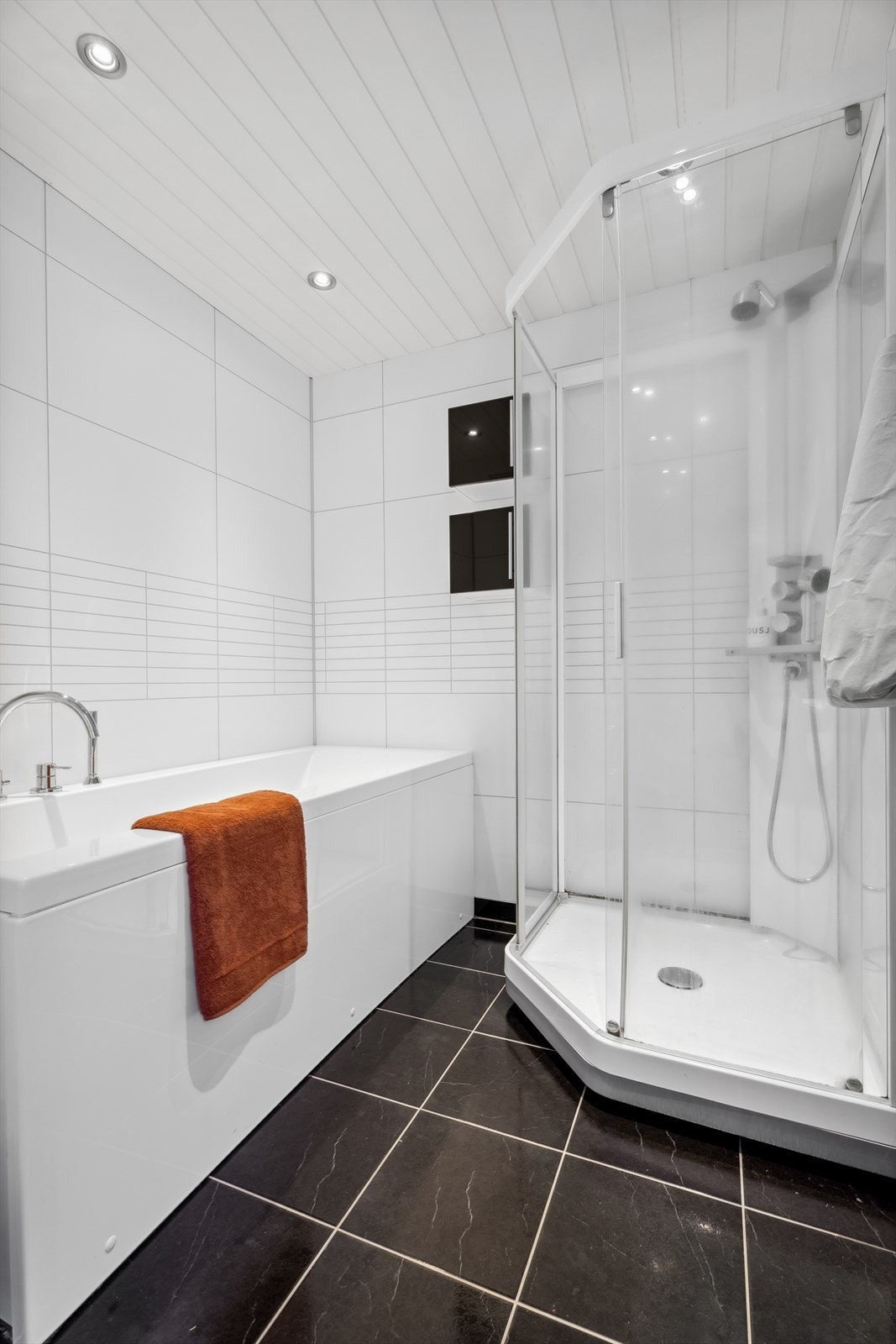 Badet er utstyrt med baderomsinnredning, dusjkabinett, badekar og vegghengt toalett Galleribilde