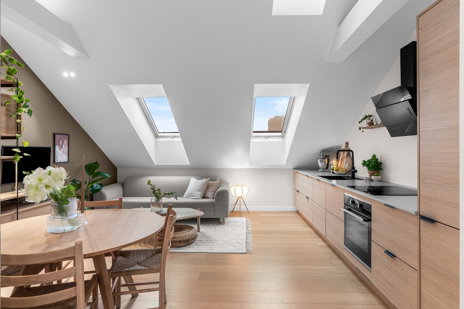 Lekkert kjøkken levert av Strai i 2021, med glatte, lyse fronter, dempefunksjoner og sort oppvaskkum av kvartskompositt nedfelt i en laminert benkeplate. Galleribilde