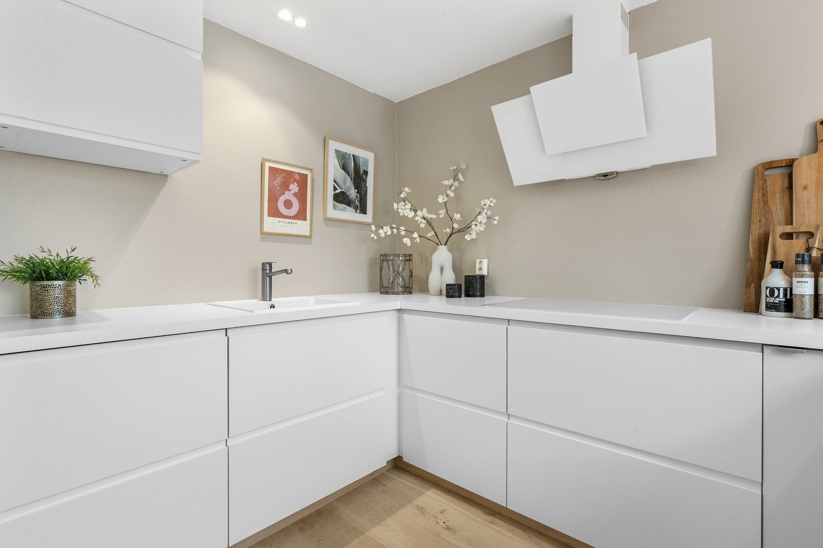 Innredningen er moderne og har stilrene, hvite fronter med gripekant, kombinert med matchende benkeplate i hvit laminat. Galleribilde