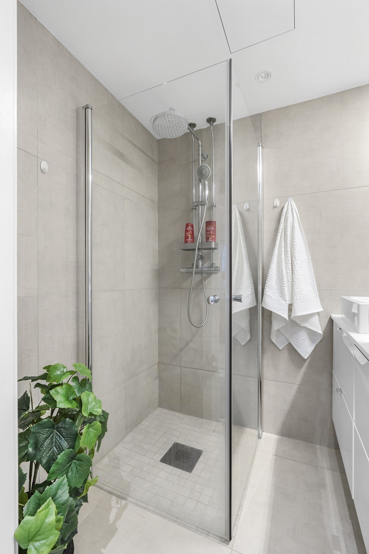 Innredningen består av to toppmonterte servanter på lys benkeplate, servantmøbel med fire hvite skuffefronter, stort servantspeil fra benk til tak med overlys, samt et dusjhjørne med innfellbare glassvegger, regnfallsdusj og hånddusj. Galleribilde