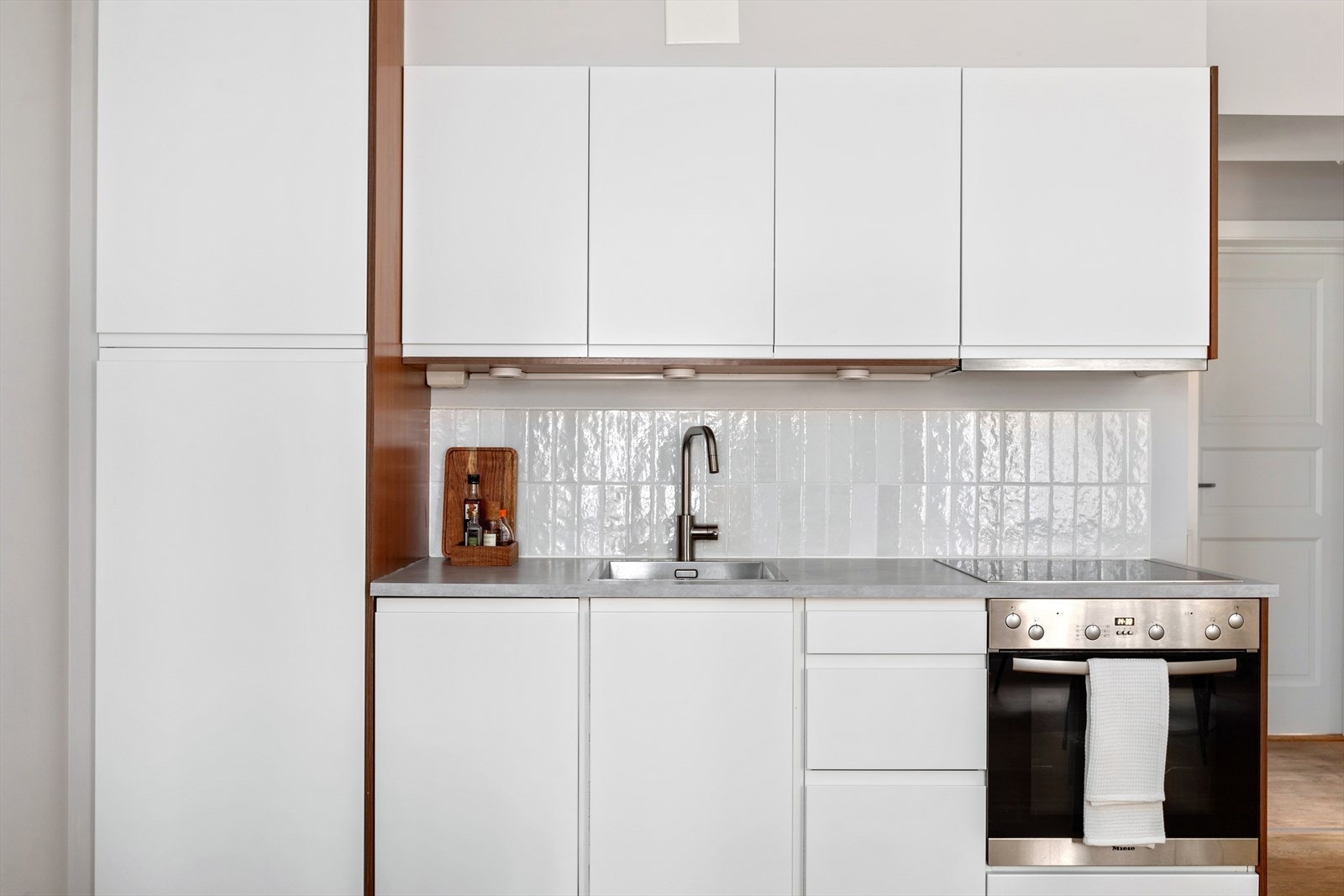 Integrerte hvitevarer som platetopp, stekeovn, oppvaskmaskin og kjøleskap med fryser. Galleribilde