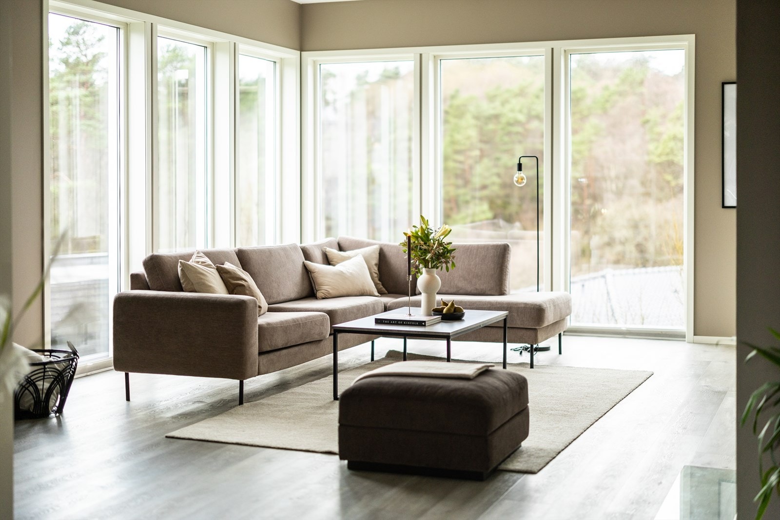 Store vinduer slipper inn sollyset og gir rommet en varm og innbydende atmosfære. Galleribilde